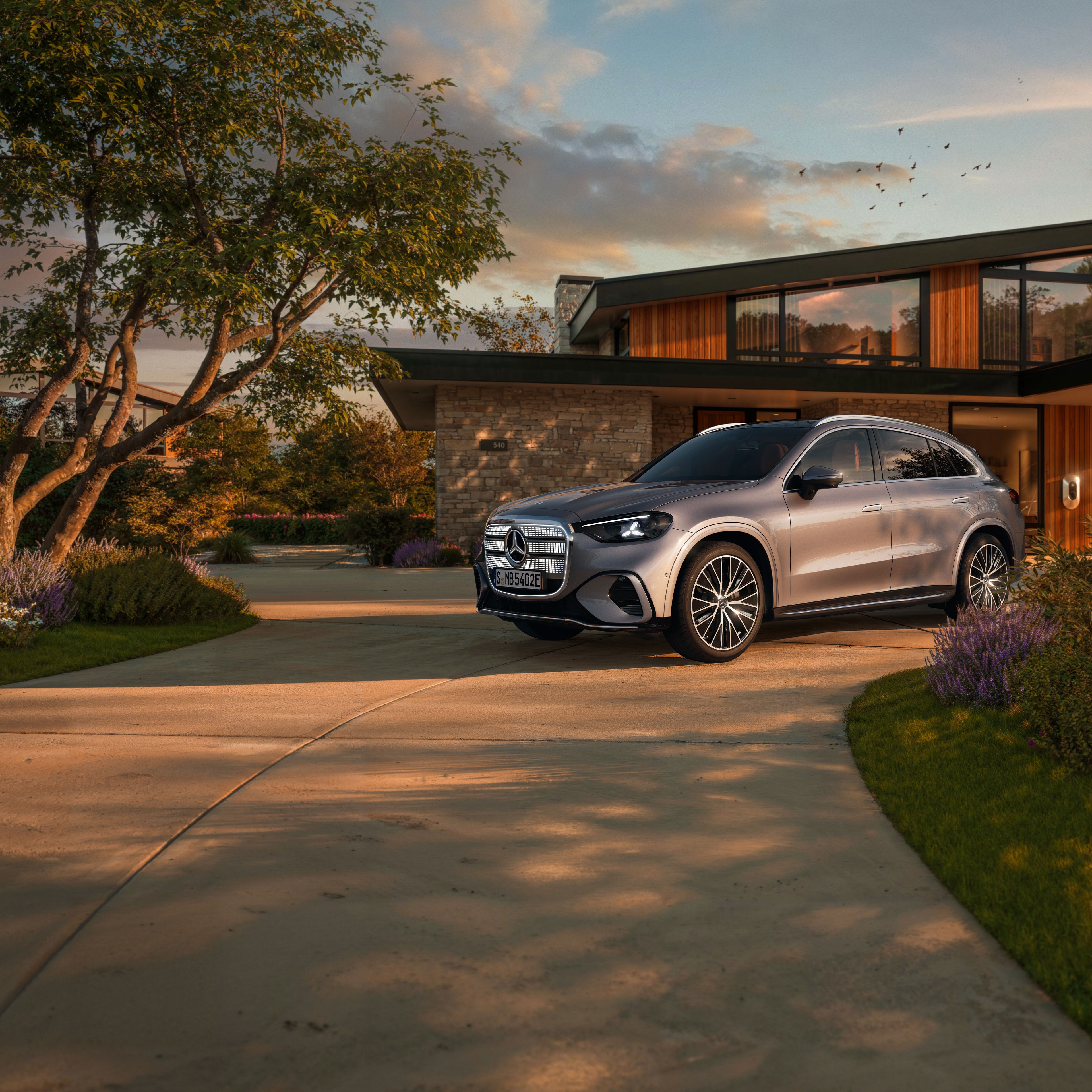 Der elektrische Mercedes-Benz GLC SUV vor einer EInfahrt.