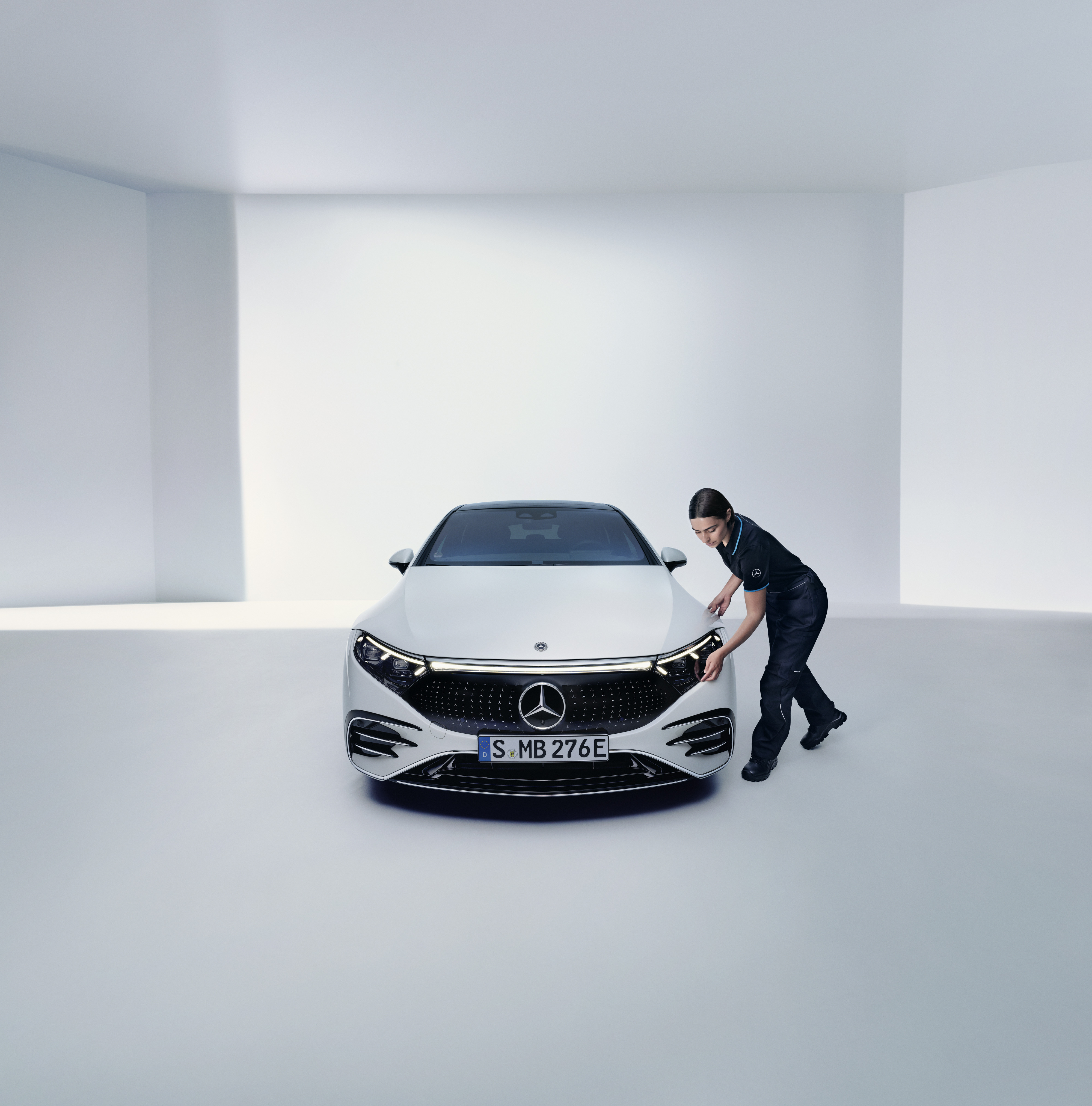 Mercedes-Benz Reparatur Ein Mercedes-Benz Technikerin überprüft einen Frontscheinwerfer.