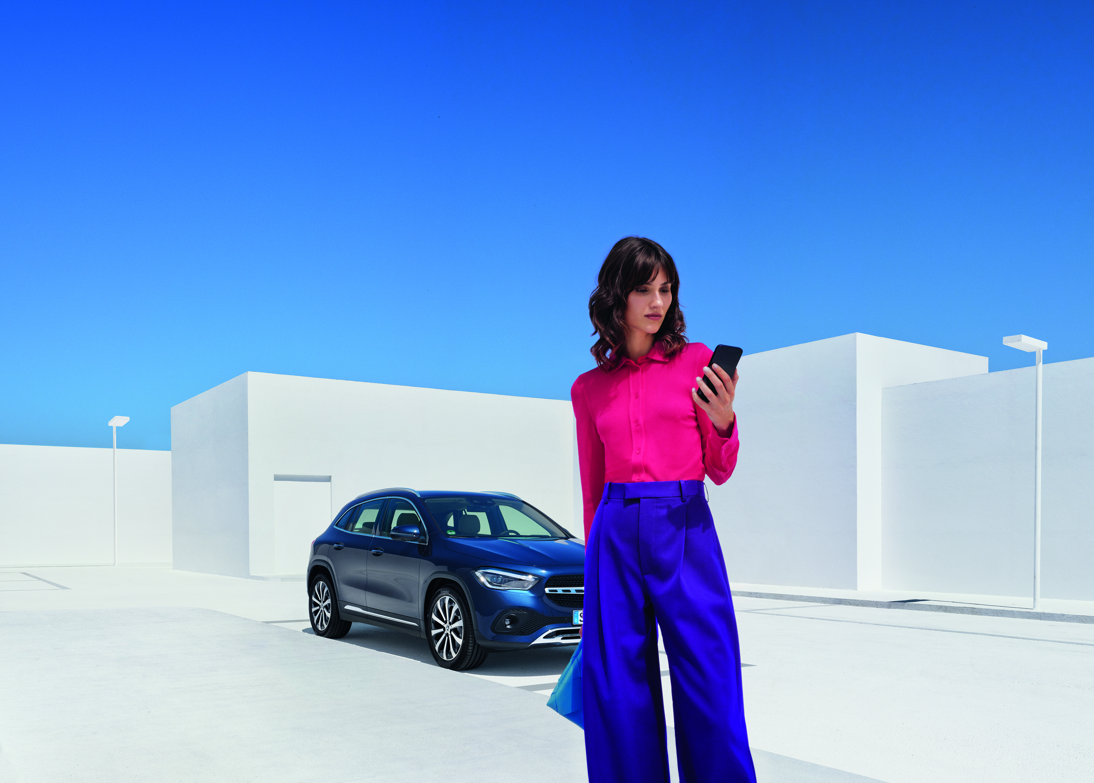 Online-Garantieverlängerung | Mercedes-Benz. Eine Frau schaut auf ihr Smartphone.