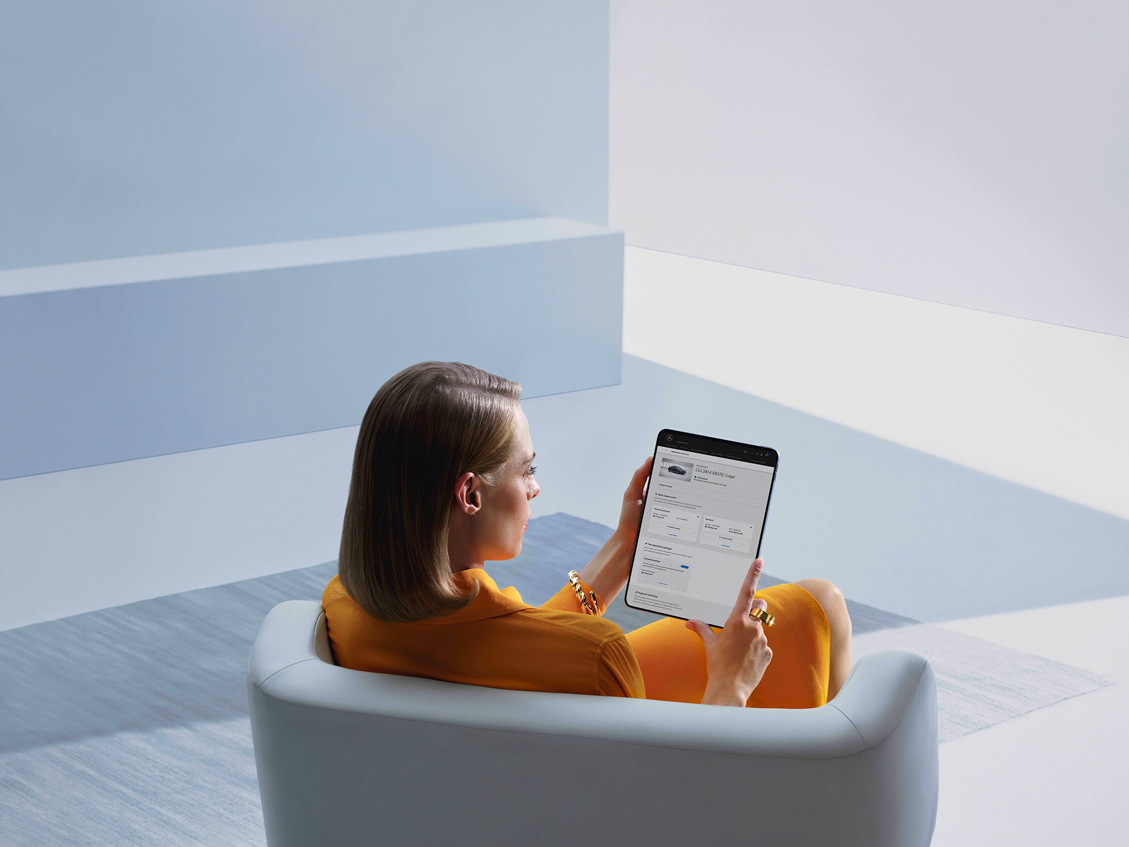 Ein Mann sitzt an seinem Schreibtisch und schaut auf seinen Laptop in einem hellen Raum.