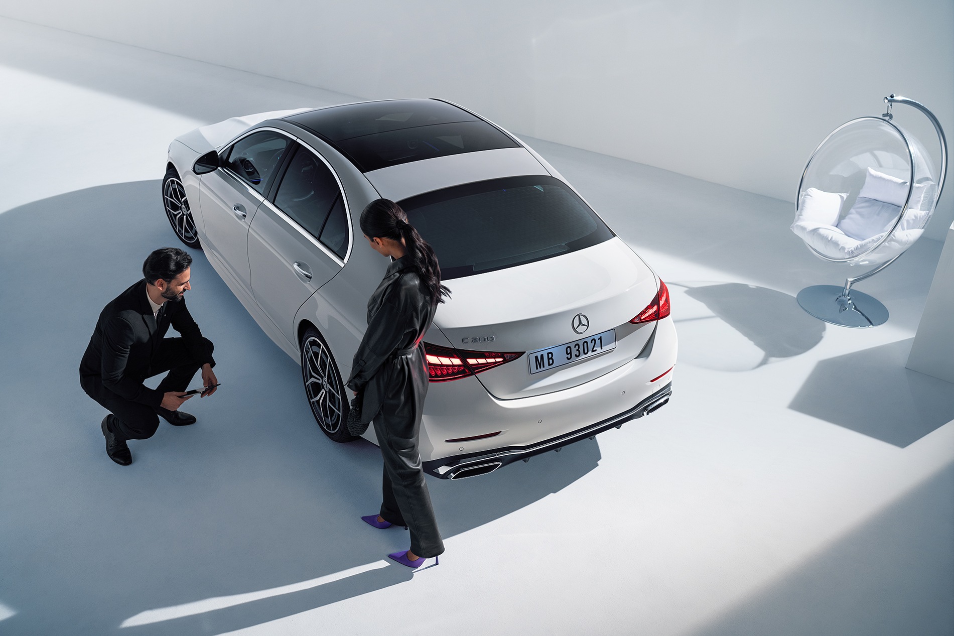 Original-Reifen | Mercedes-Benz Zwei Personen schauen auf das linke Hinterrad von einem Mercedes-Benz.