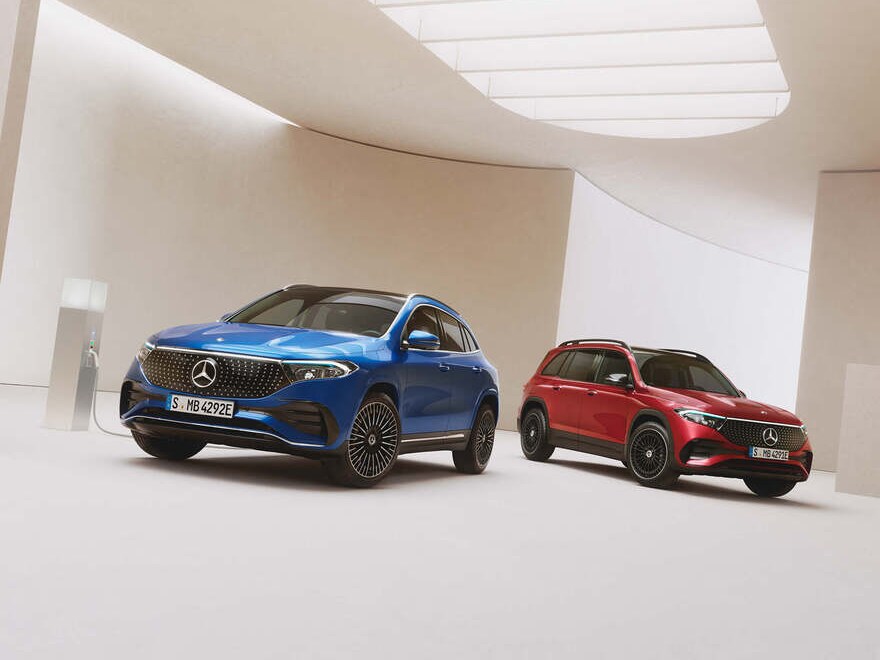 Zwei elektrische Fahrzeuge von Mercedes-Benz auf beigem Grund.