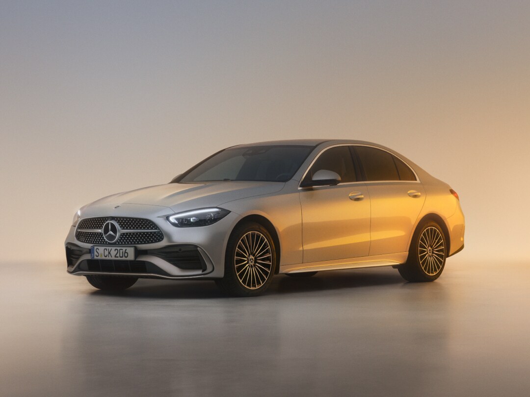 Eine C-Klasse Limousine von Mercedes-Benz steht auf neutralem, hellen Grund mit Lichtreflexen.