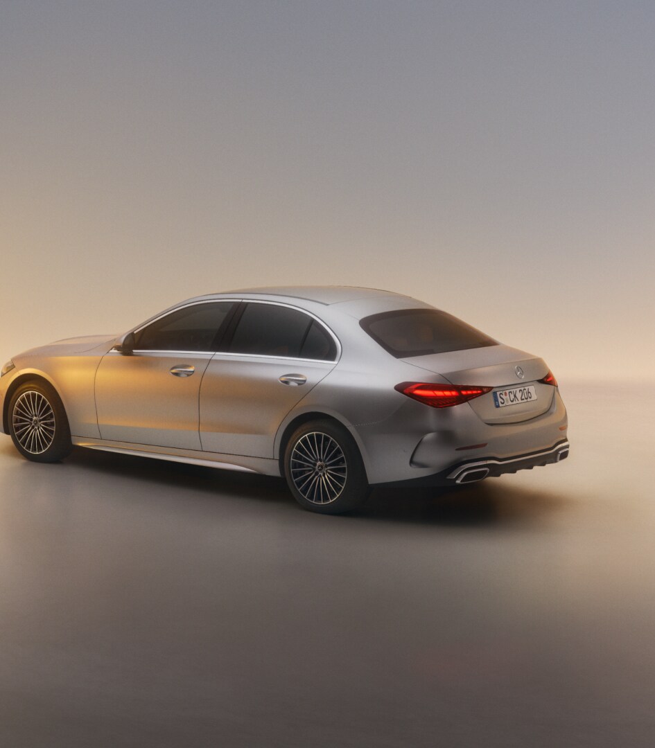 Eine silberne C-Klasse Limousine von einer seitlich-schrägen Perspektive auf neutralem Grund.