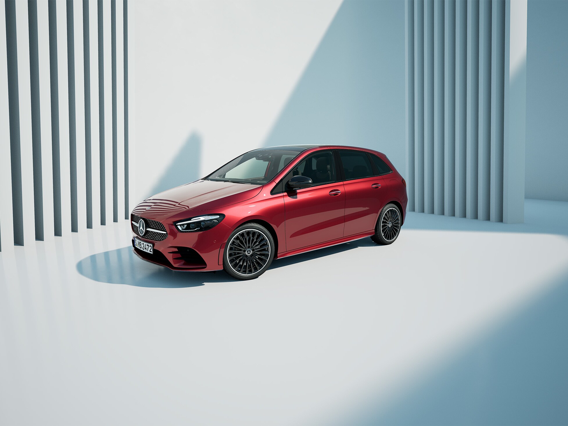 Eine rote B-Klasse auf hellem Grund vor einer Wand mit Lamellen.