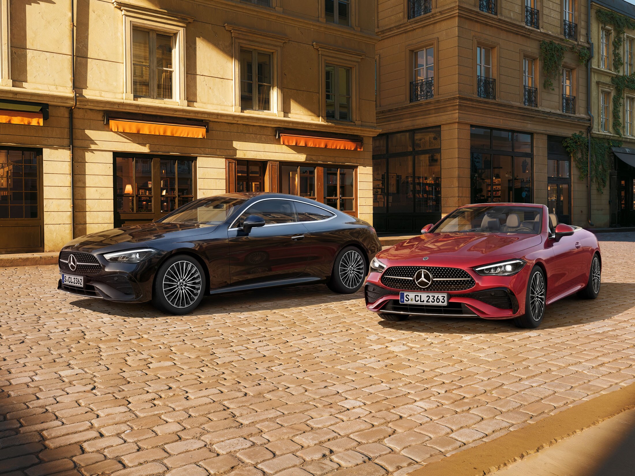 Ein schwarzer Mercedes-Benz CLE Coupé und roter CLE Caprio seitlicher Frontansicht, parkend vor einem Bistro.