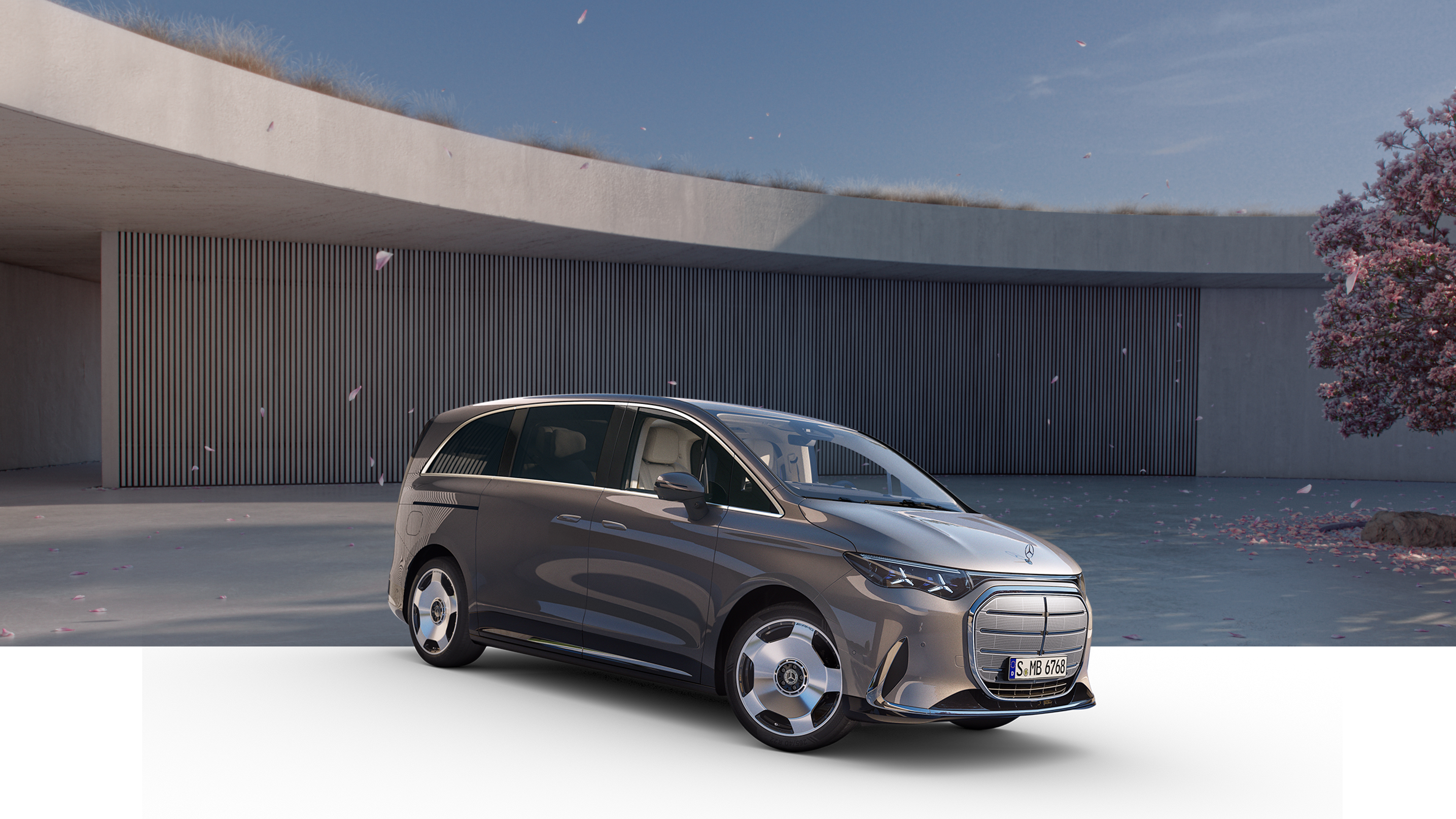 VLE | Mercedes-Benz Gezeigt wird halb Freigestellter VLE von Mercedes-Benz. Parkend vor einem modernem Gebäude mit einem Kirschbaum an der Seite.