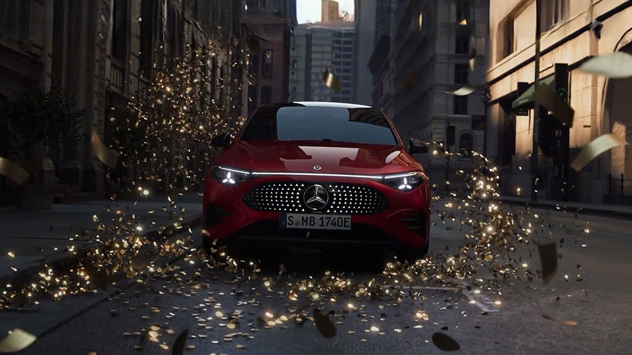 Der neue vollelektrische CLA Shooting Brake von Mercedes-Benz parkend in einer Straße und umhüllt von goldenem Glitter.