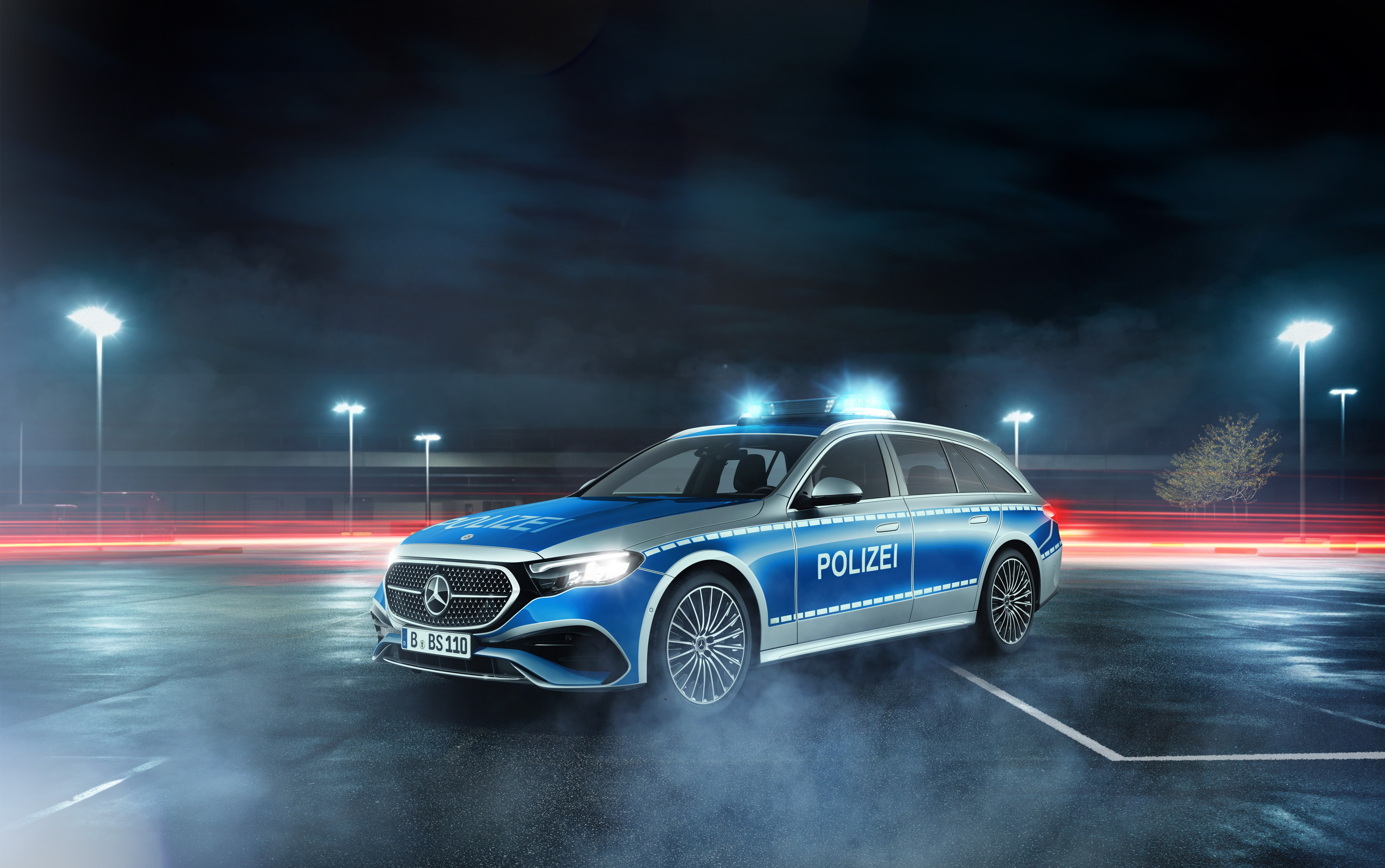 Polizei | Mercedes-Benz Ein Mercedes-Benz Polizei Fahrzeug bei Nacht mit eingeschaltetem Blaulicht auf einem Parkplatz.