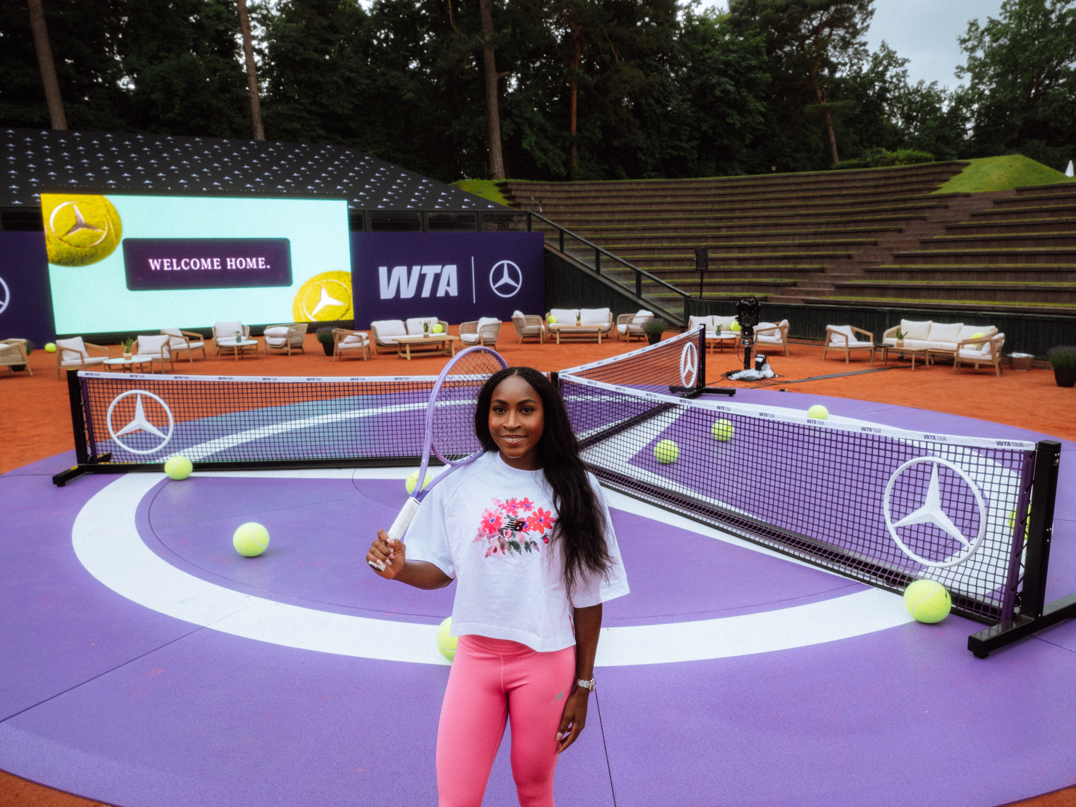 Markenbotschafterin Coco Gauff mit Tennisschläger in der Hand steht auf einem violetten Court.