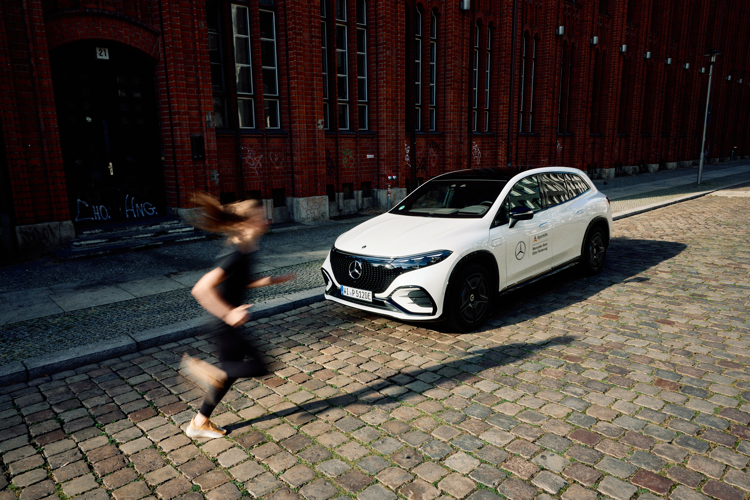 Deutsche Sporthilfe | Mercedes-Benz Eine joggende Frau vor einem Mercedes-Benz | Mercedes-Benz