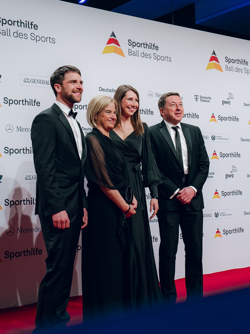 Ein Gruppe Menschen vor einer Wand mit dem Deutsche Sporthilfe Logo