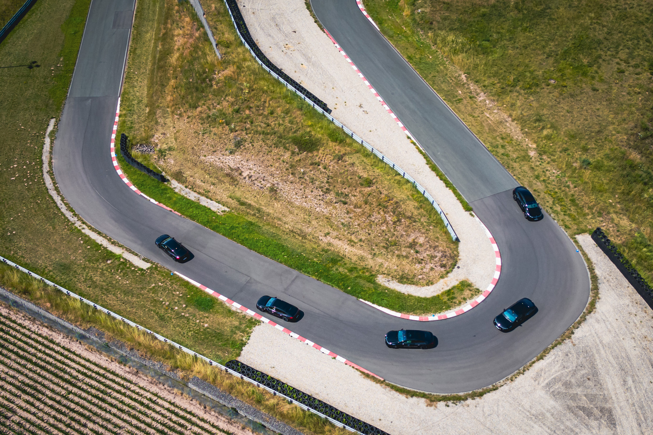 Driving Events | Mercedes-Benz Eine Kolonne aus fünf Fahrzeugen von Mercedes-Benz fährt in Formation auf einer Rennstrecke.