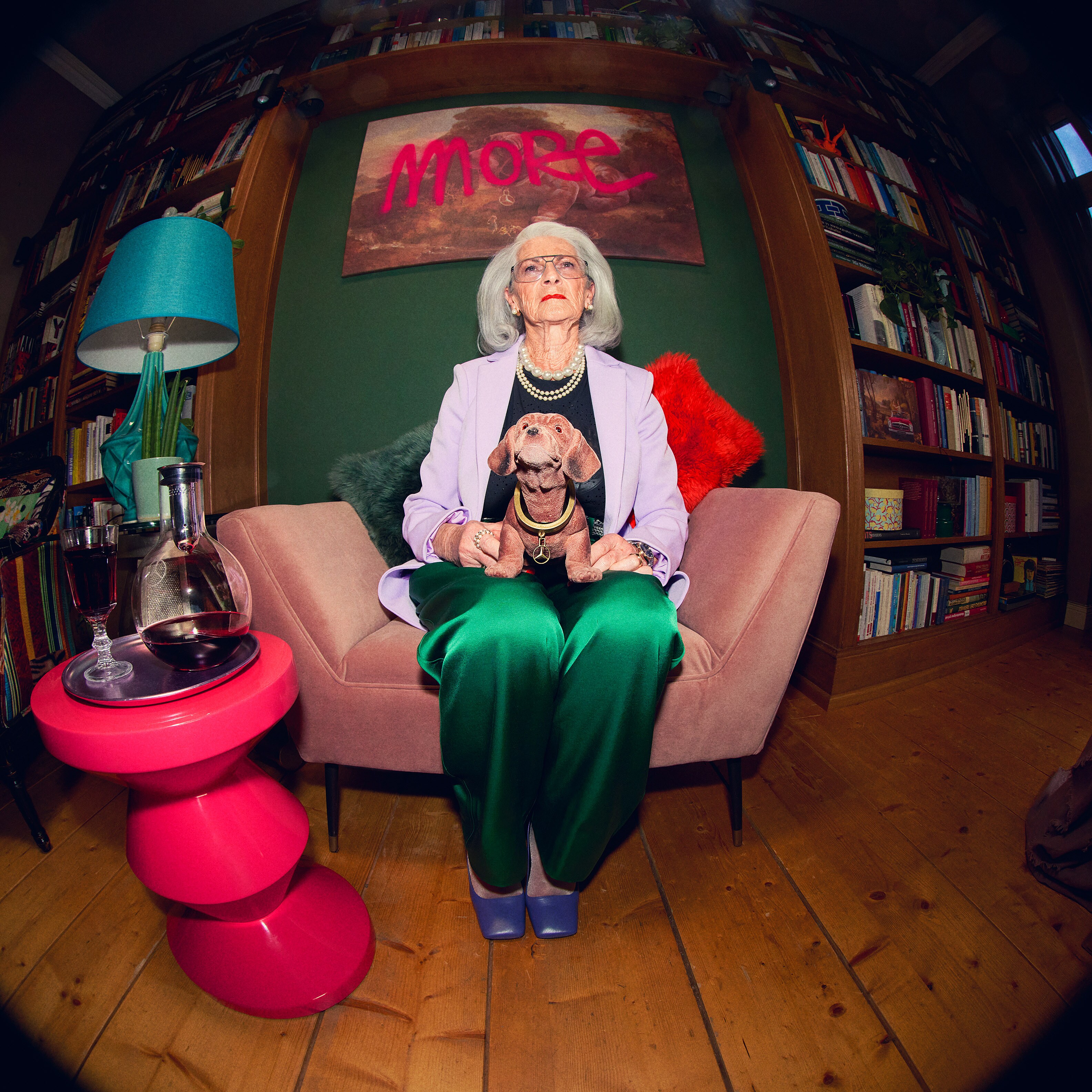 Eine Frau sitzt auf einem Sofa mit einem Wackeldackel auf dem Schoß.