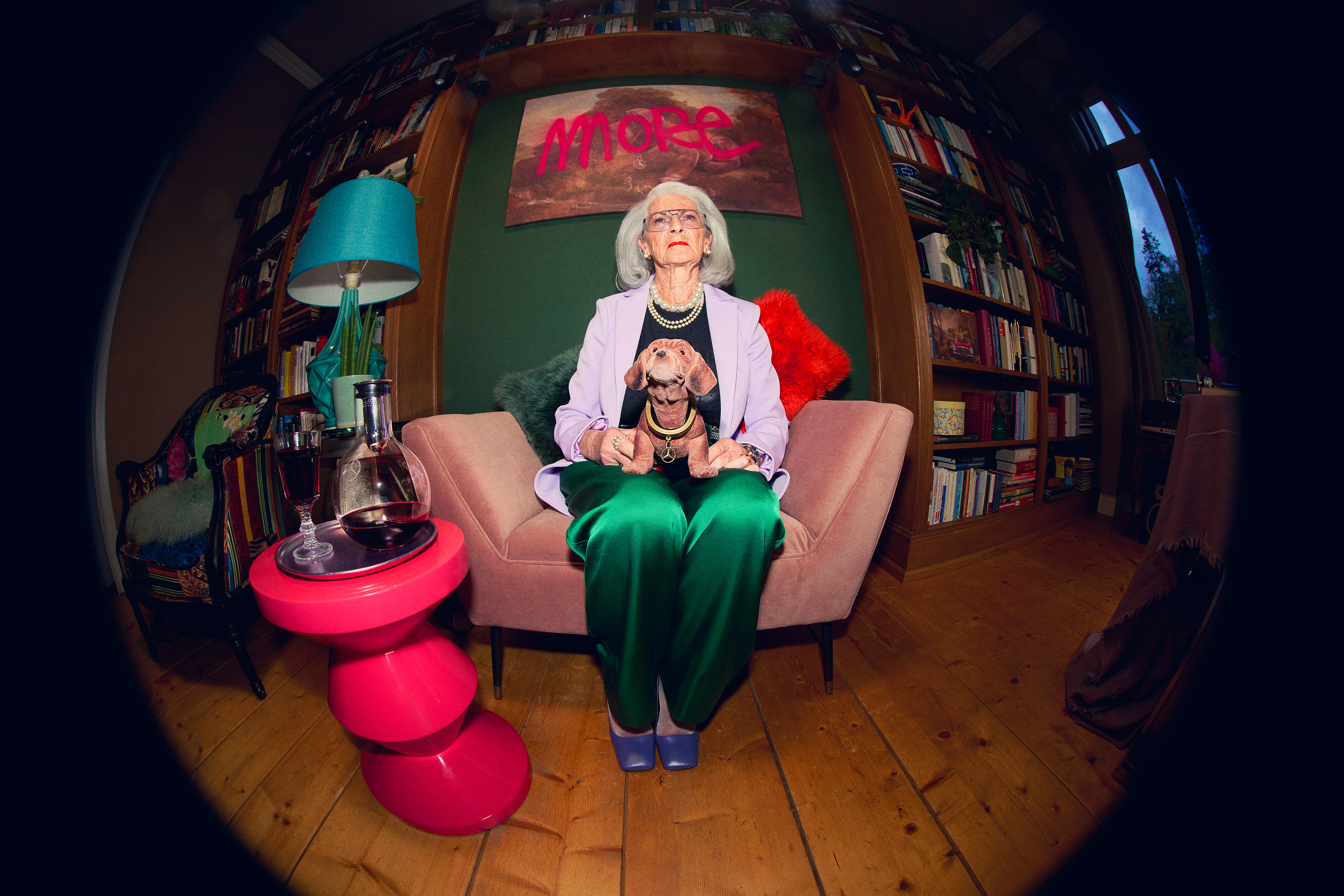 Mercedes-Benz Collection Eine Frau sitzt auf einem Sofa mit einem Wackeldackel auf dem Schoß.