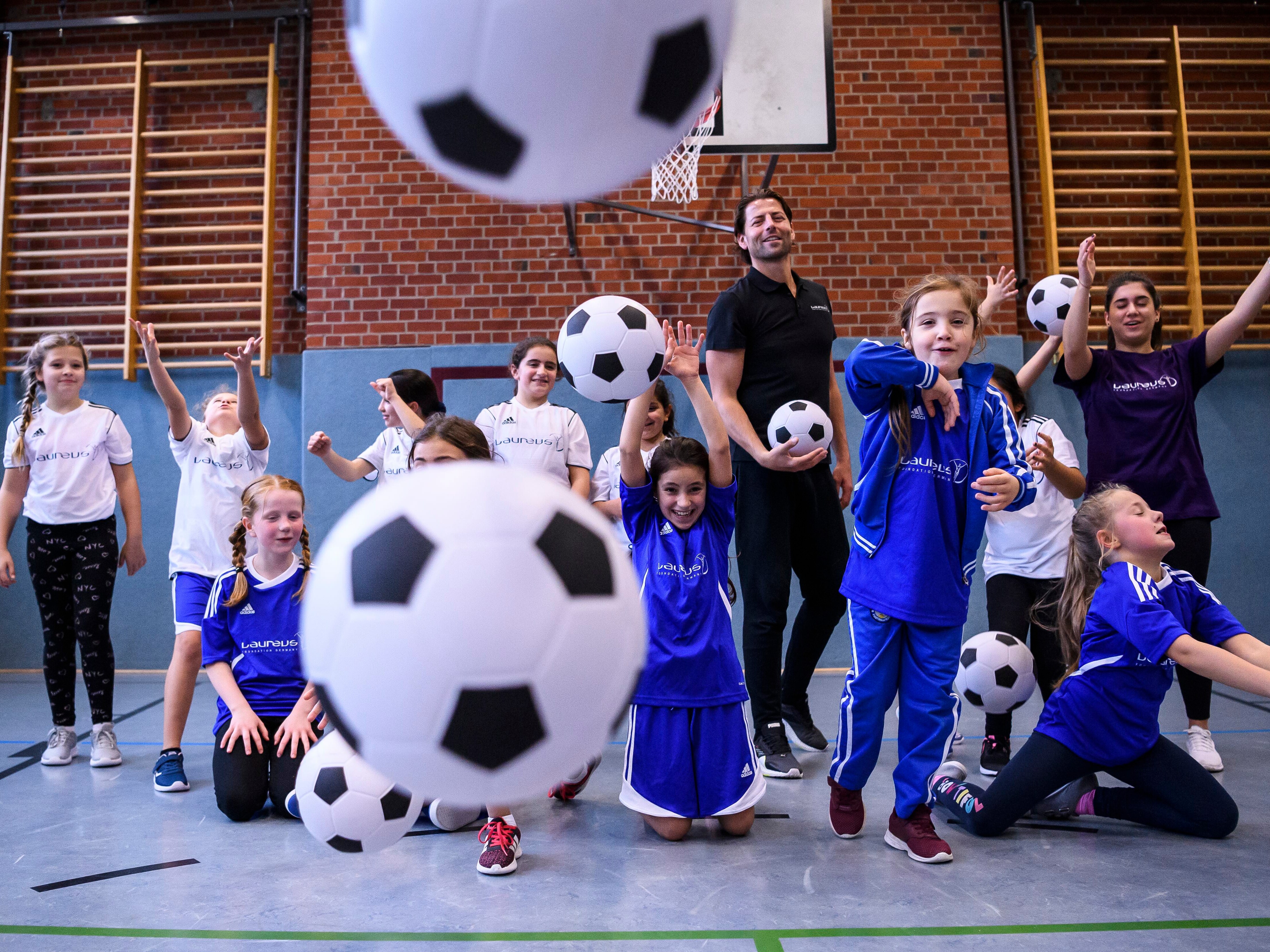 eine Gruppe Jugendlicher mit Fußbällen 