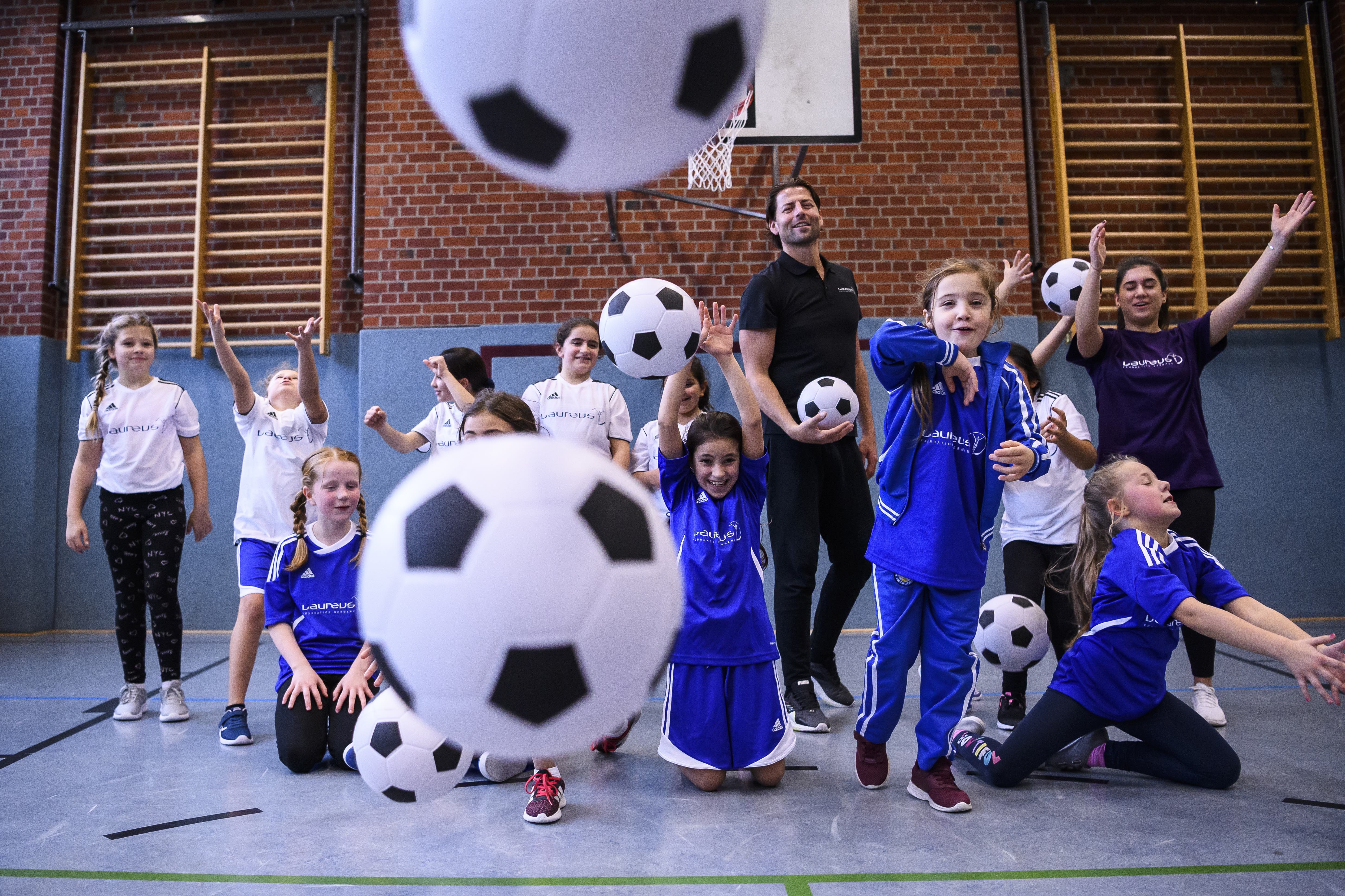 Laureus | Mercedes-Benz eine Gruppe Jugendlicher mit Fußbällen