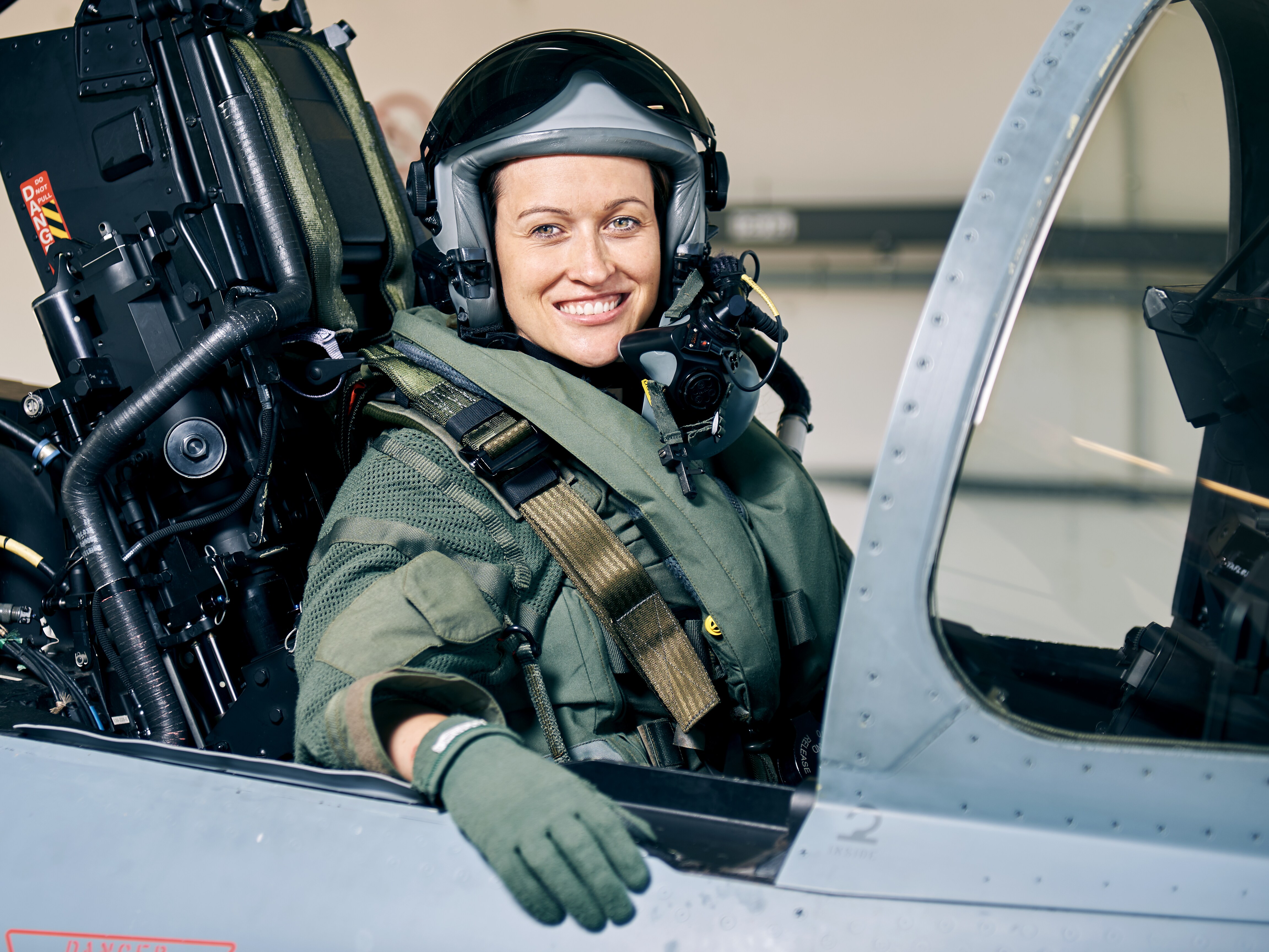 Nicola Winter sitzt in einem Bundeswehr-Jet und lächelt dabei in die Kamera. 