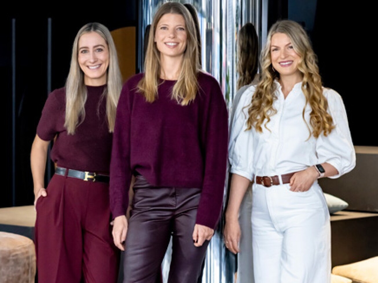 3 Frauen von She's Mercedes stehen nebeneinander und lächeln in die Kamera 