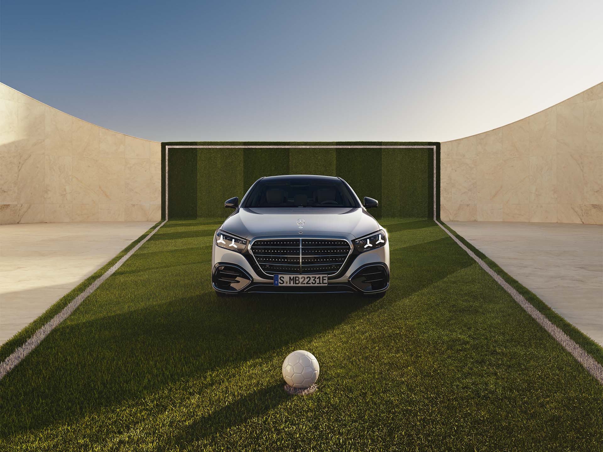 140 Jahre Innovation | Mercedes-Benz Eine S-Klasse in Frontalansicht auf einem Fußballfeld. Vor dem Mercedes-Benz Modell liegt ein Fußball.