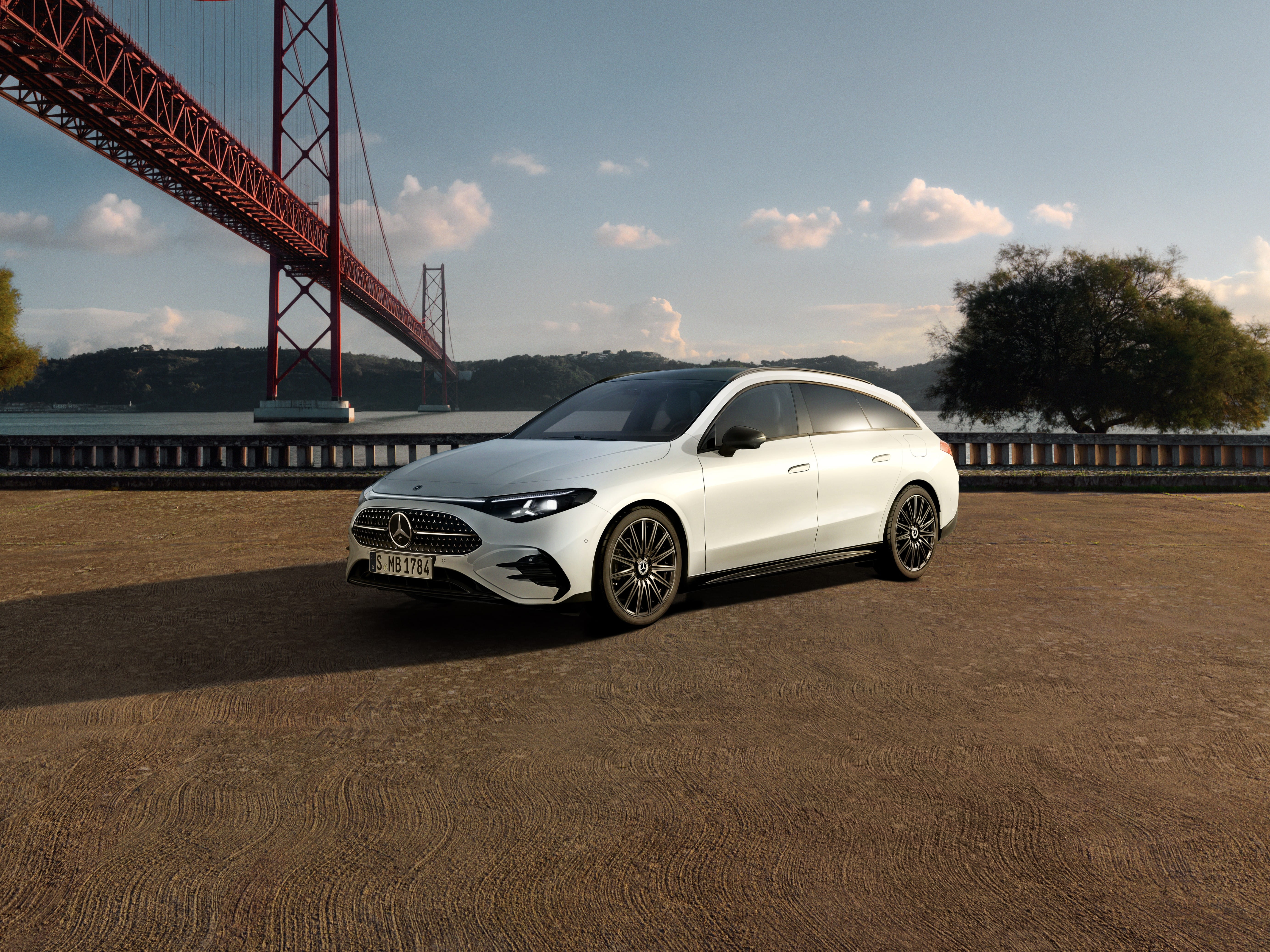 140 Jahre Innovation | Mercedes-Benz Der Mercedes-Benz CLA Shooting Brake in Frontalasicht steht vor einer Brücke am Wasser im Sonnenuntergang.