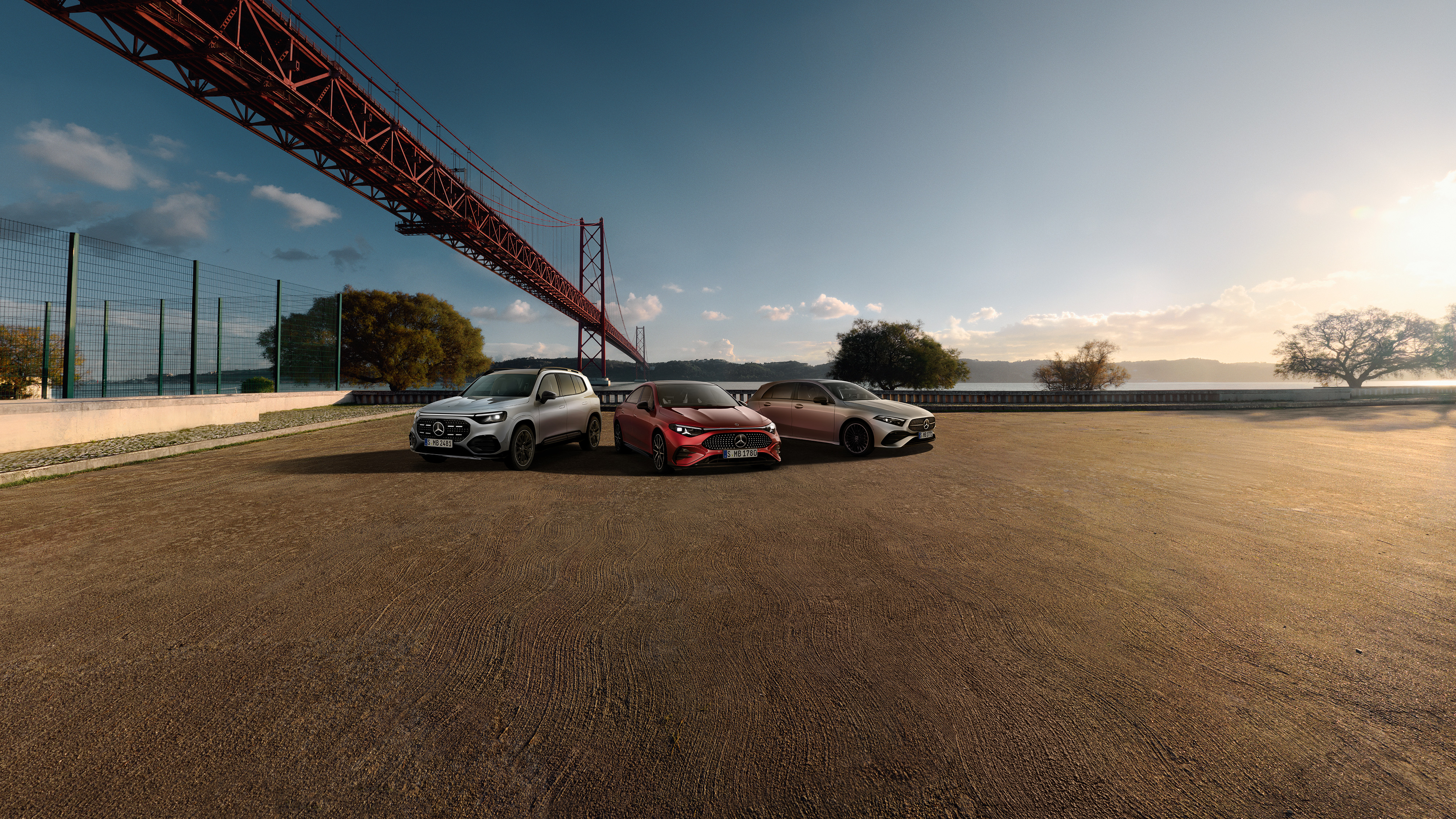 3 Mercedes-Benz Modelle stehend vor einer Brücke.