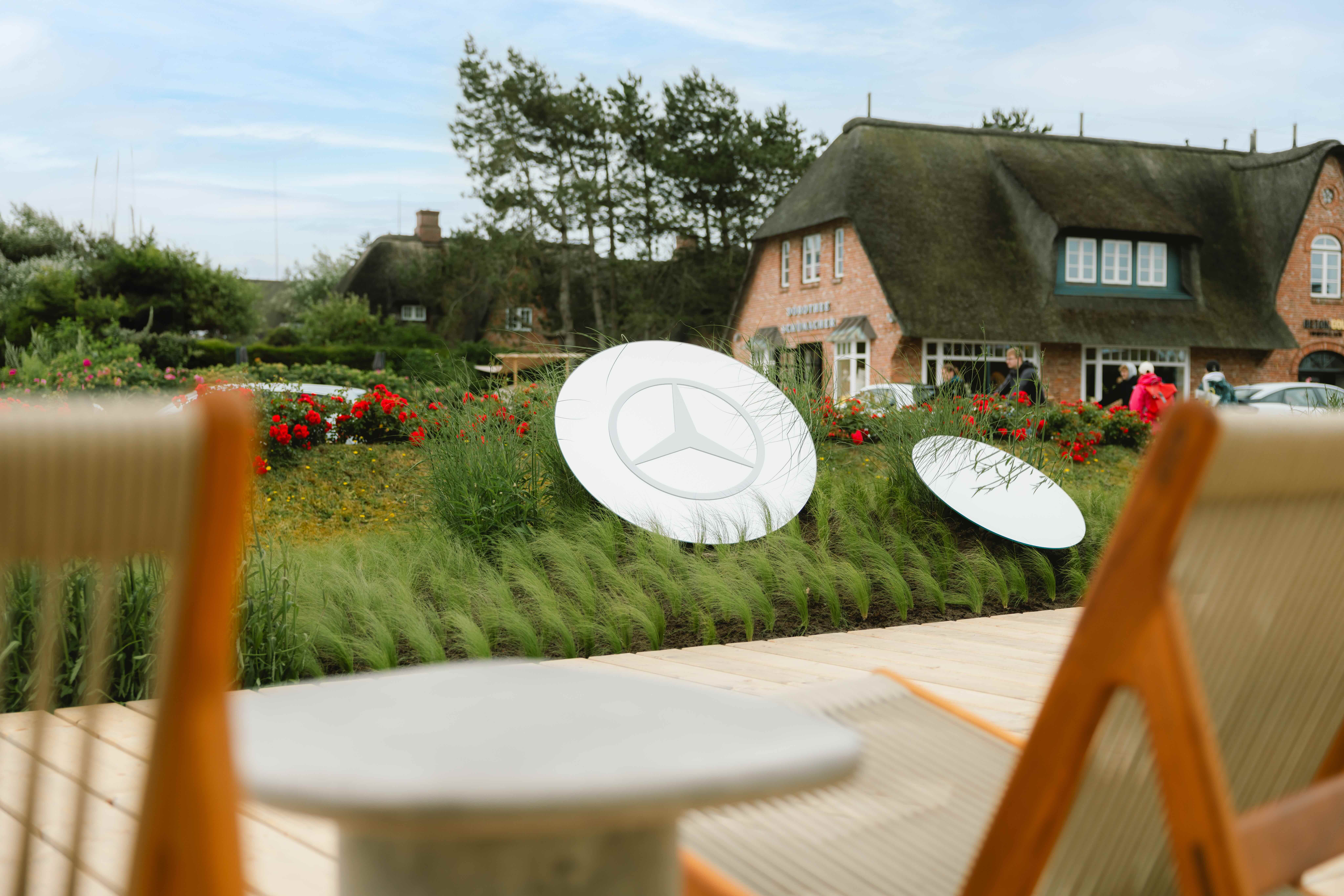 Mercedes-Benz x Kampen | Mercedes-Benz Mercedes-Benz Stern auf einer Wiese vor einem Haus.