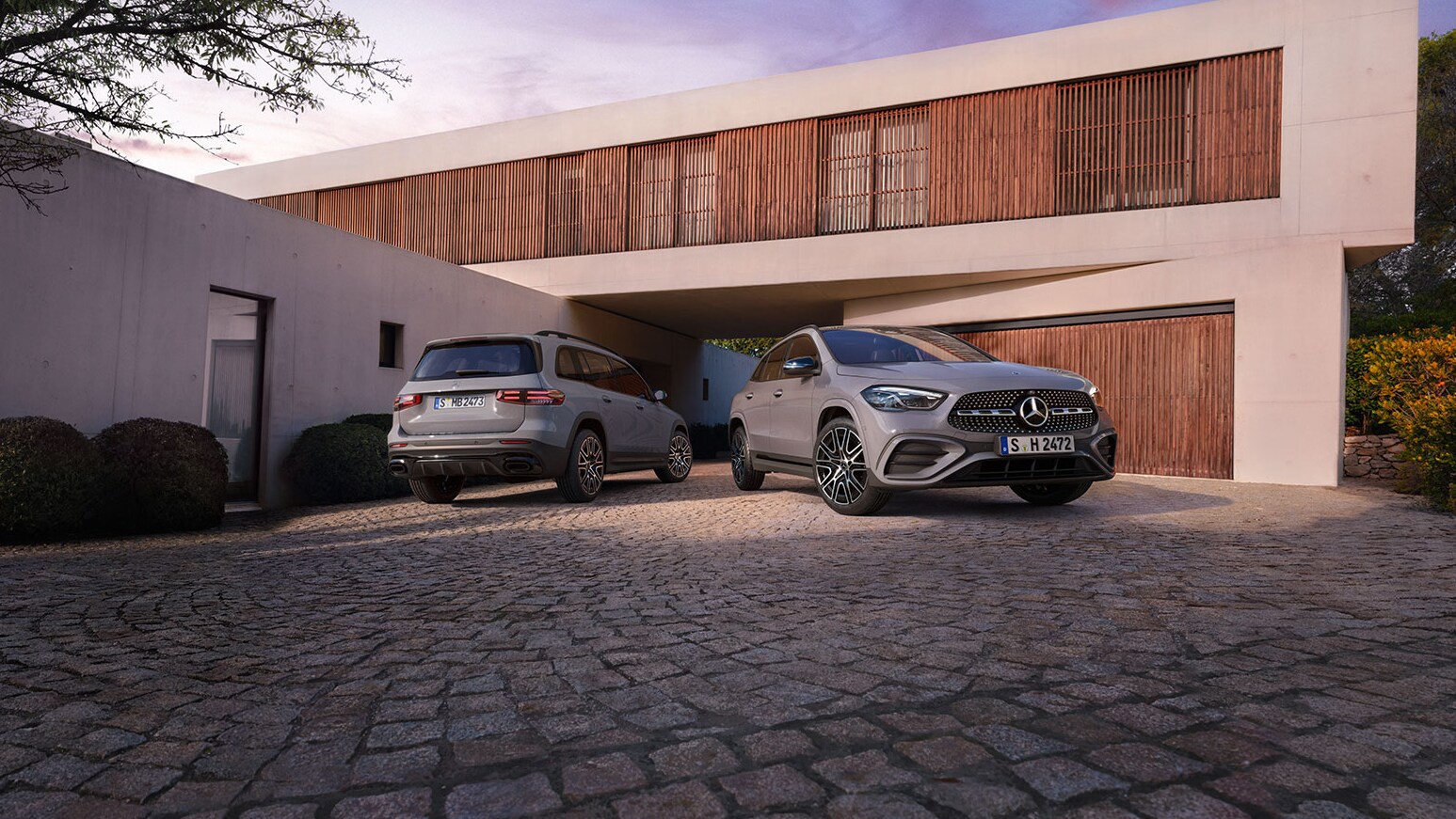 Der Mercedes-Benz GLA Special Edition und GLB Special Edition vor einem modernen Haus.