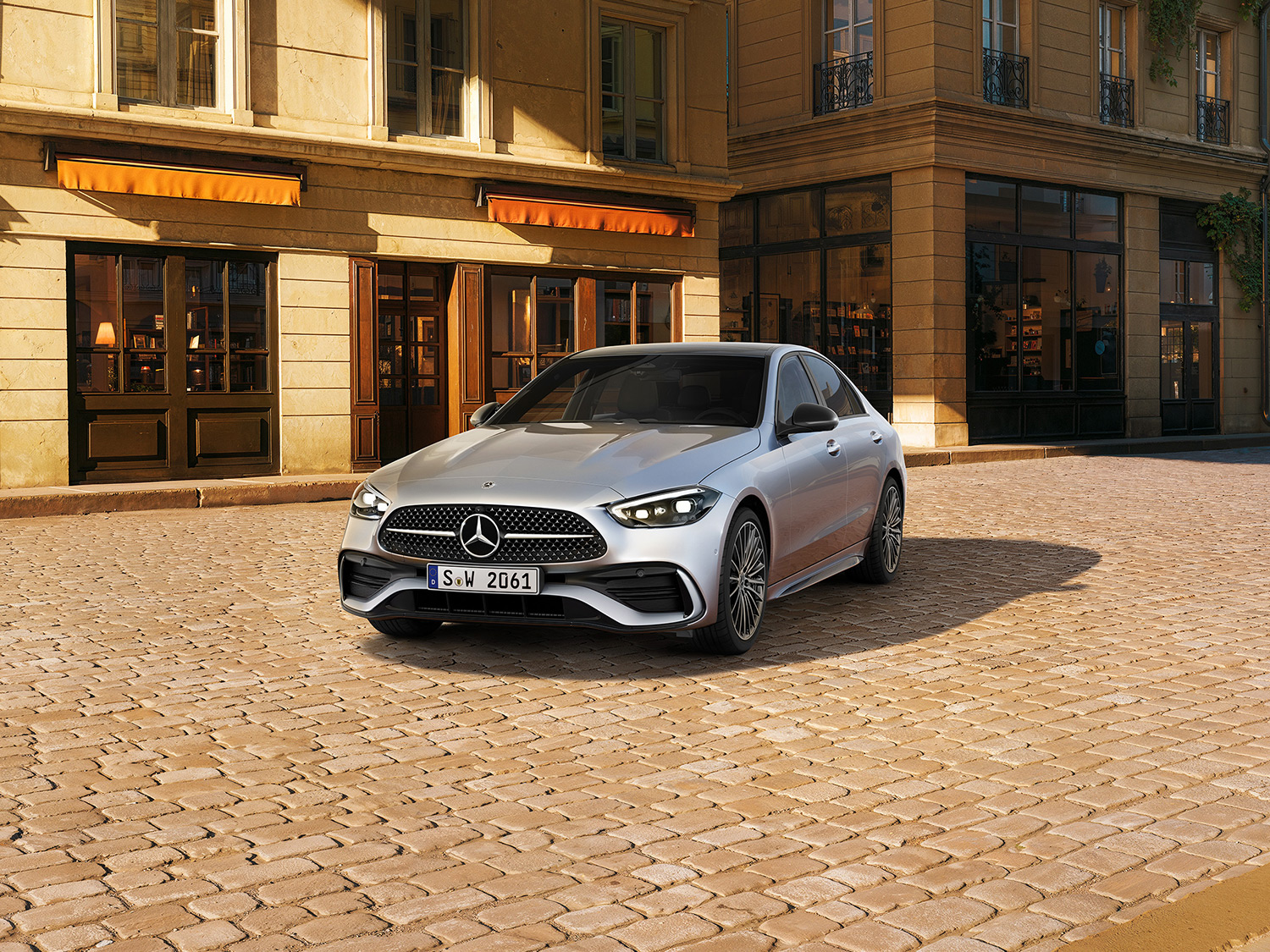 Silberne Mercedes-Benz C-Klasse Limousine parkend auf einem Kopfsteinpflaster. Zeit die sich Lohnt | Mercedes-Benz