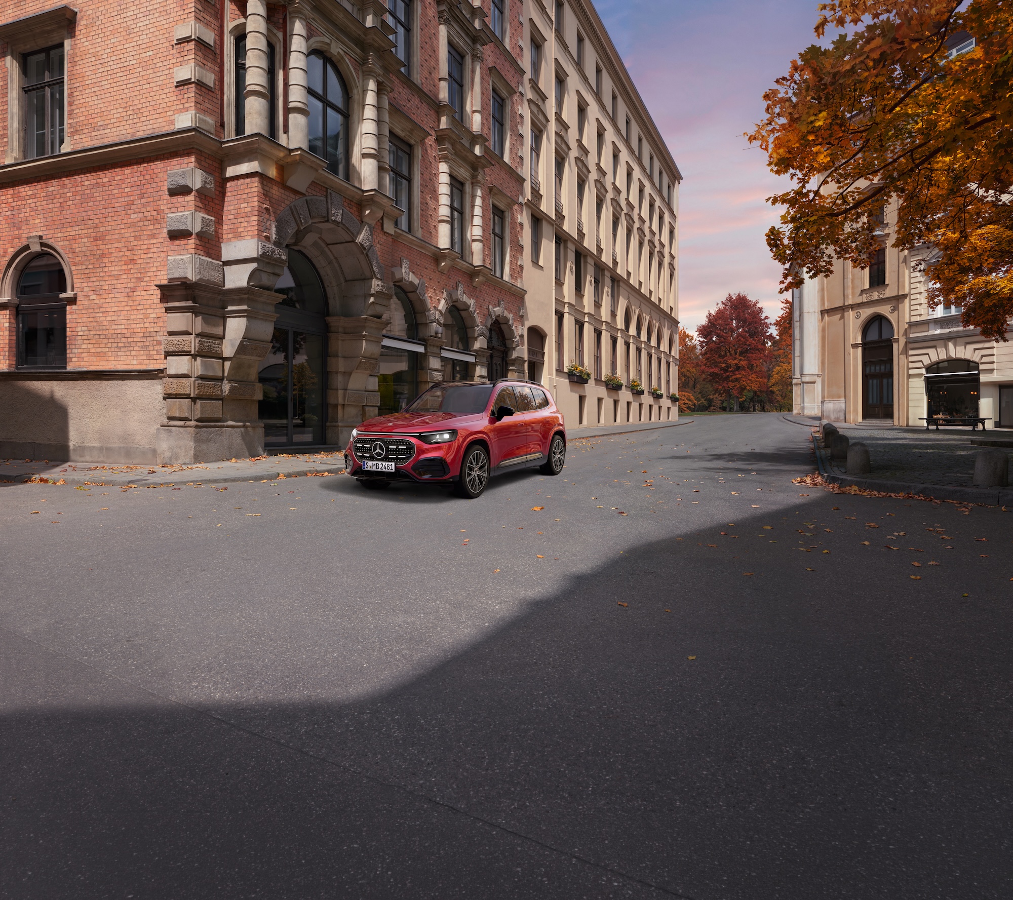 Warum entscheiden | Mercedes-Benz Ein roter Mercedes-Benz GLB steht in der Stadt auf einer Straßenecke bei herbstlichem Wetter.