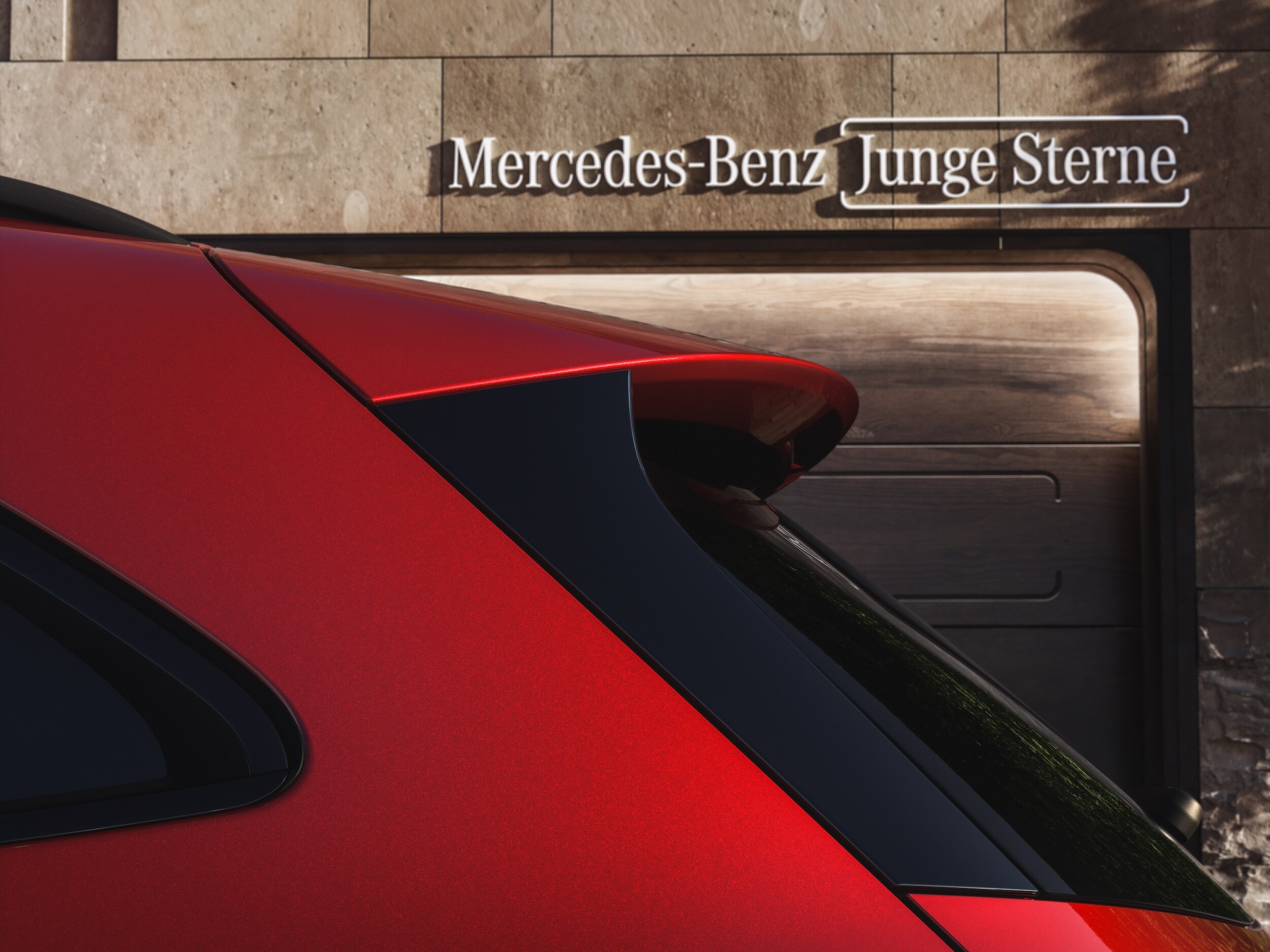 Ein rotes Auto steht vor einem Haus mit der Aufschrift: Mercedes-Benz Junge Sterne