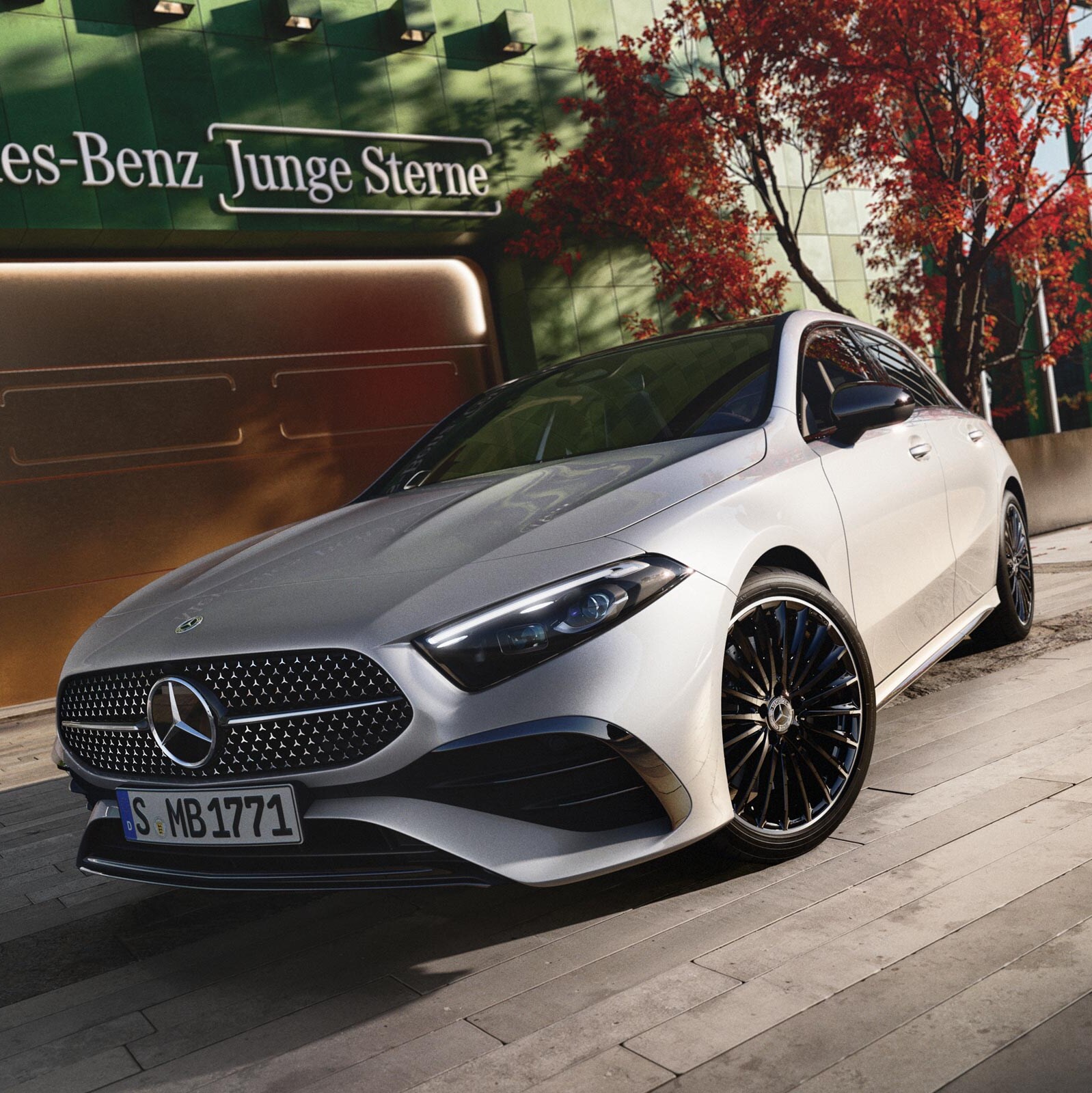 Ein Mercedes-Benz Modlel in herbstlicher Kulisse stehend vor einem Tor.