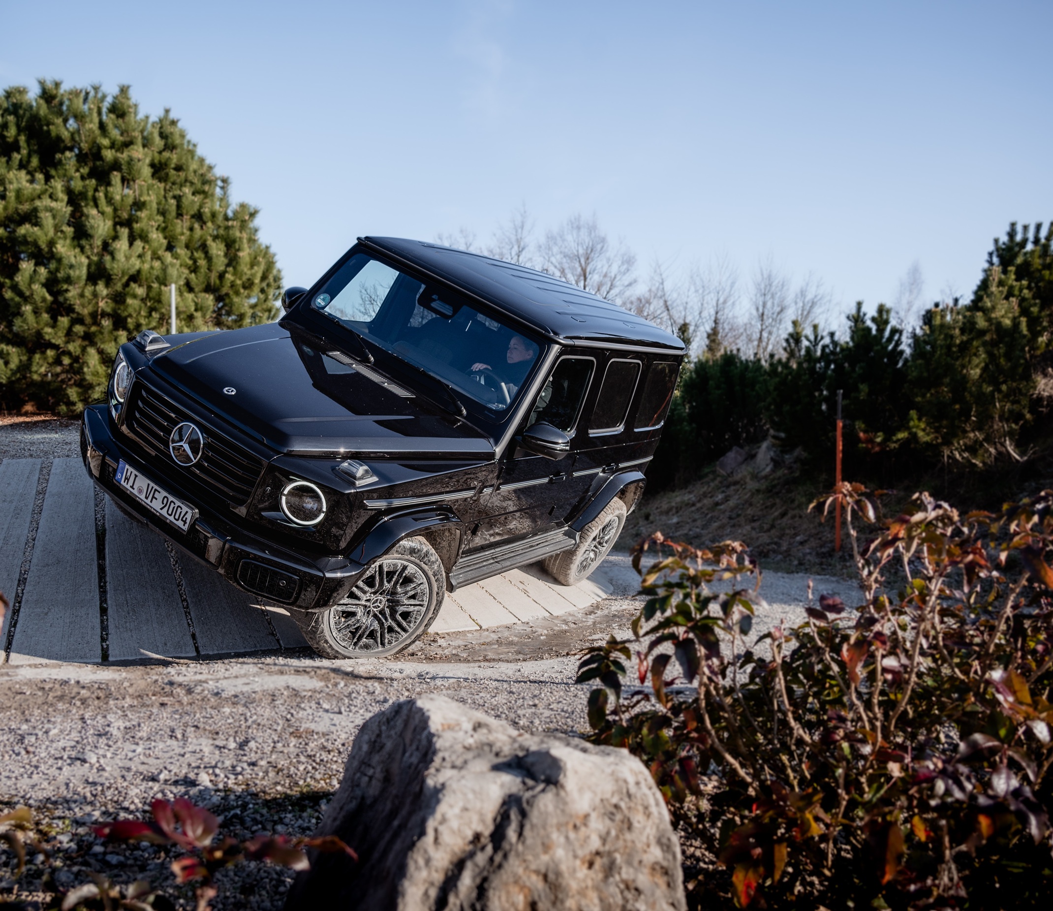 Fahrerlebnisse im Kundencenter | Mercedes-Benz. eine G-Klasse fährt über einen Holzsteg