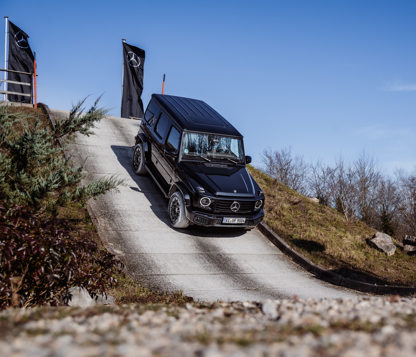 Fahrerlebnisse im Kundencenter | Mercedes-Benz. eine G-Klasse fährt eine steile Straße hinab