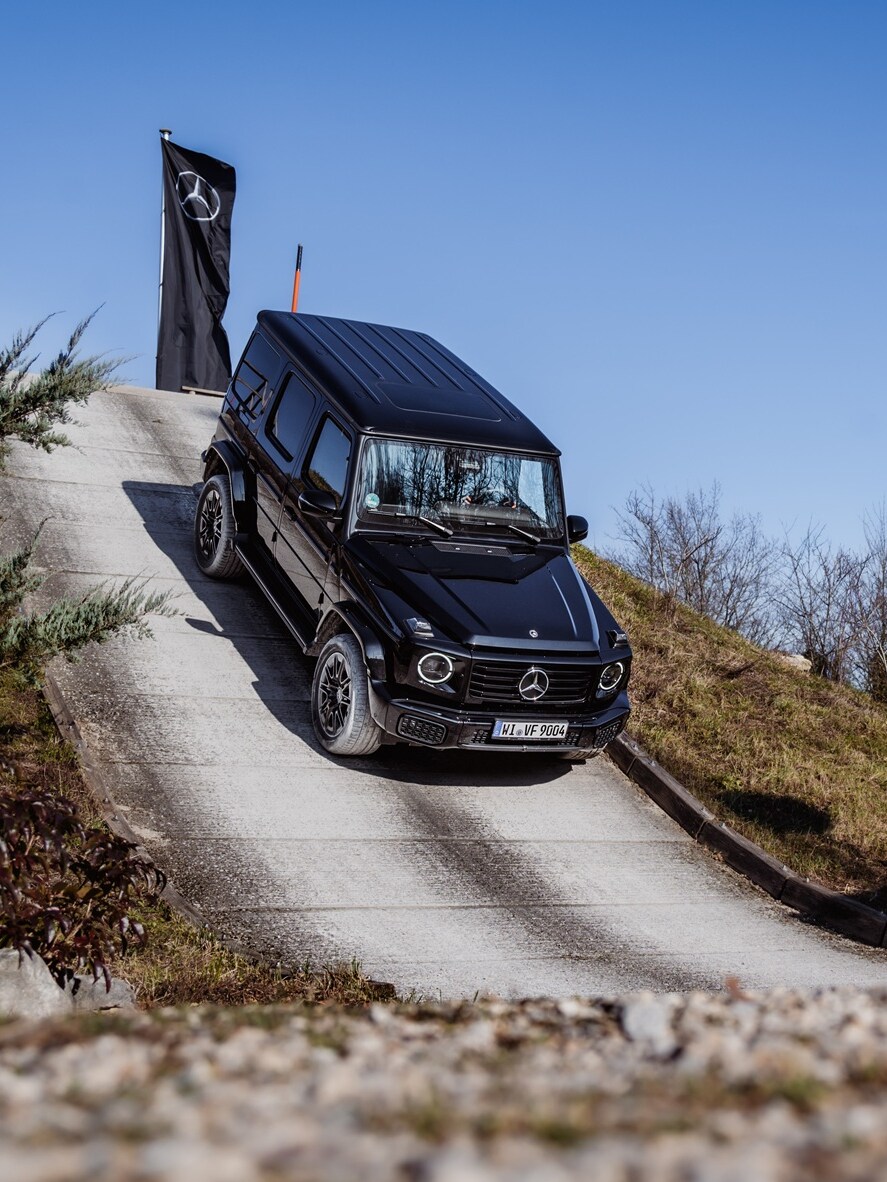 eine G-Klasse fährt eine steile Straße hinab