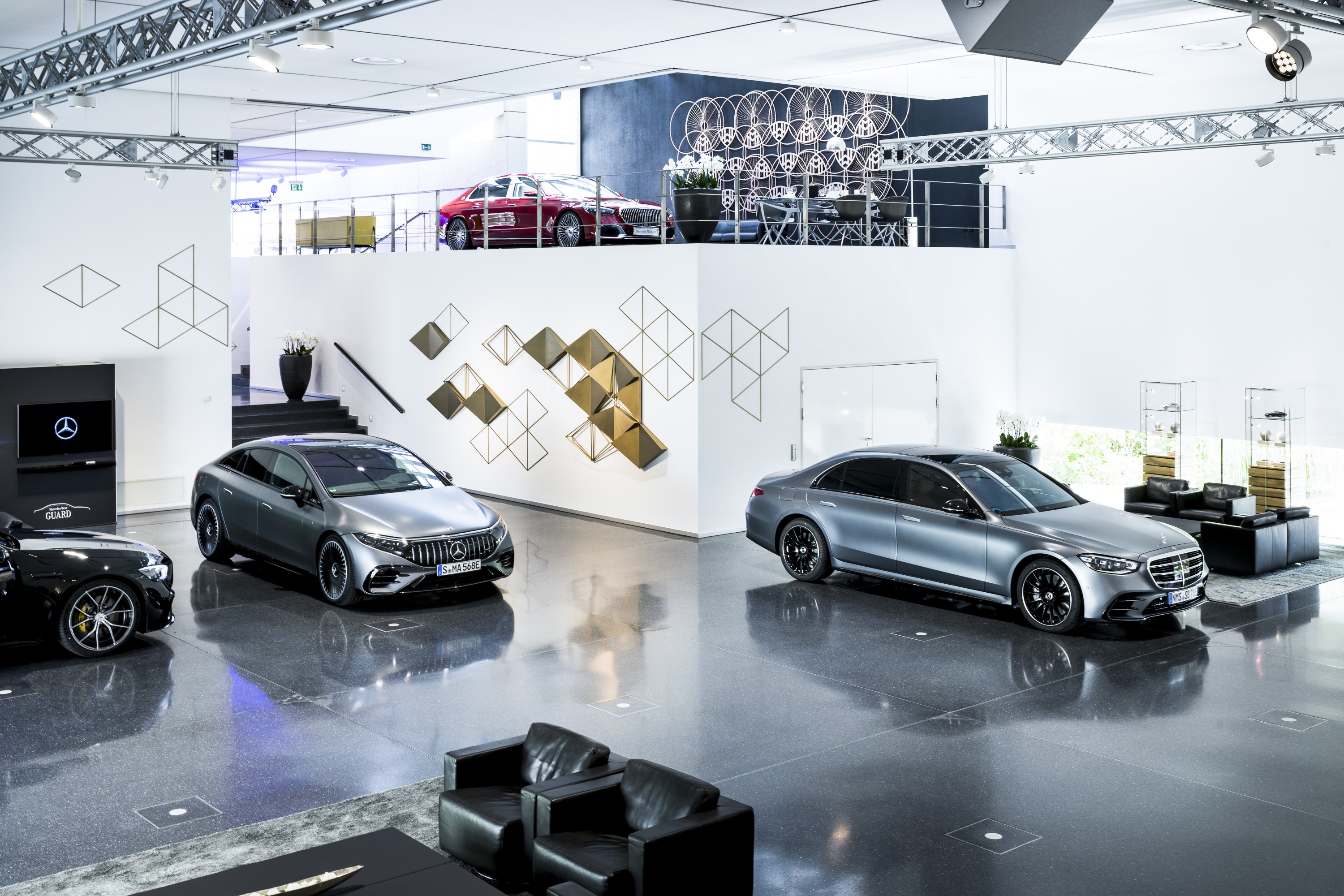 Ihre Fahrzeugabholung | Mercedes-Benz. Ein silbernes Mercedes Benz Modell steht im Ausstellungsraum des Center of Excellence.