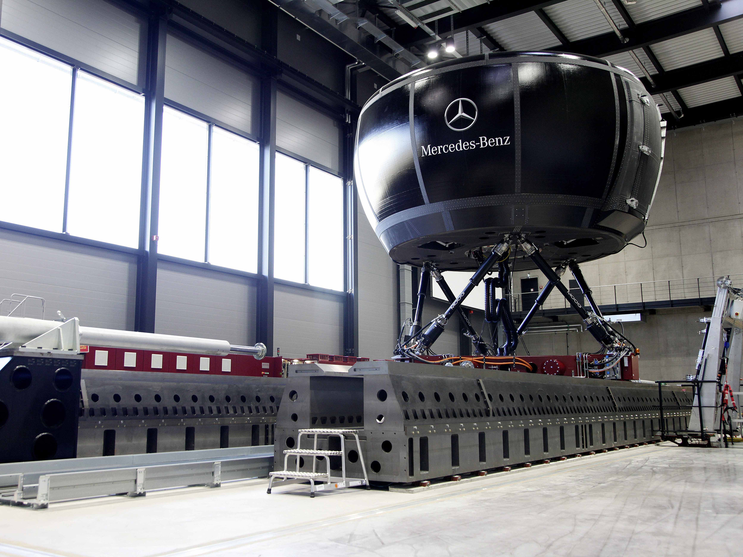 Studienteilnahme | Mercedes-Benz. Ansicht eines Testfahrzeugs von Mercedes-Benz in einer großen Lagerhalle.