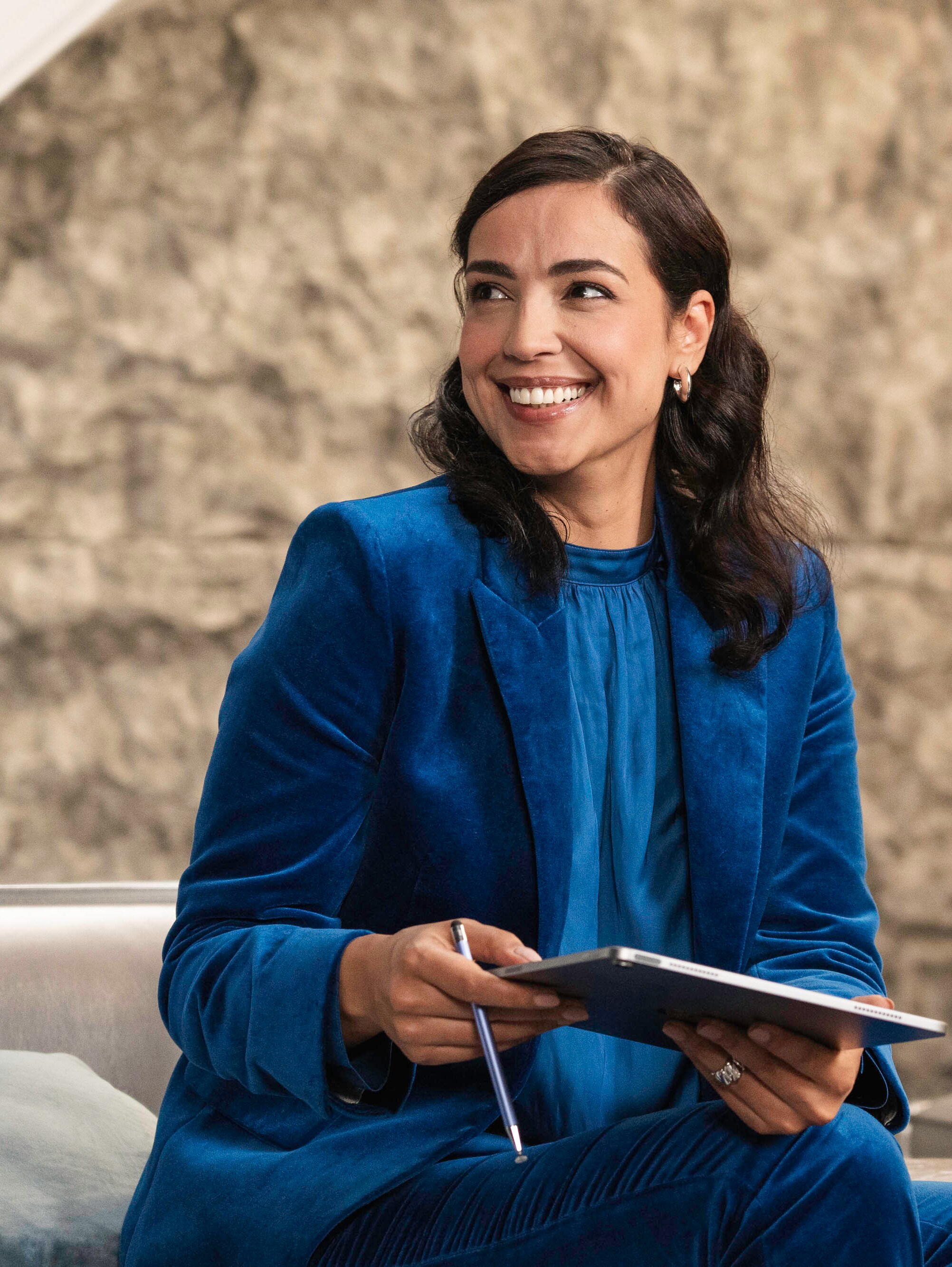 Eine lächelnde Person mit einem Tablet.