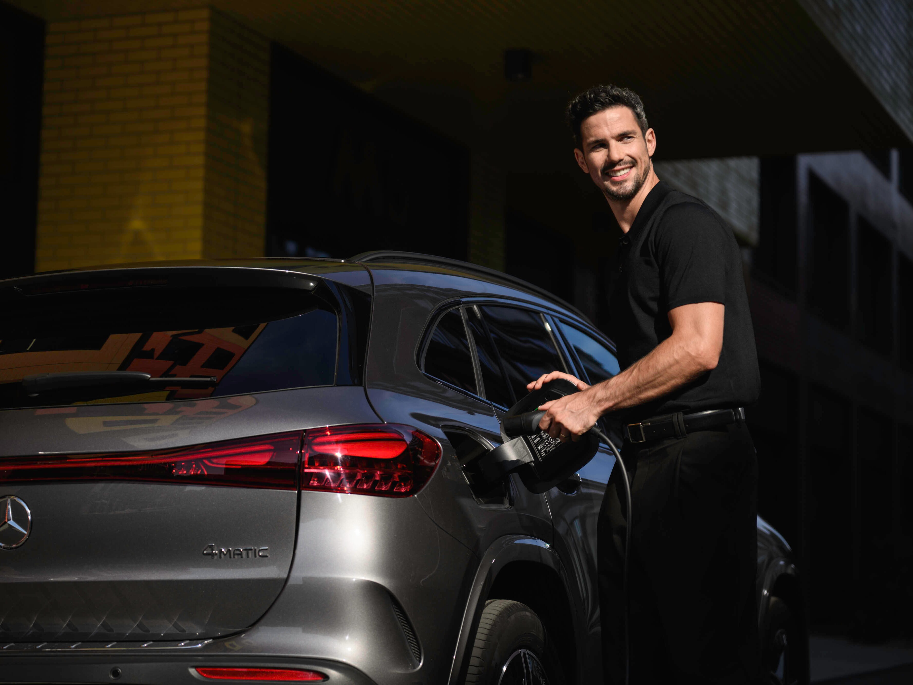 Eine Person, die einen Mercedes-Benz lädt.