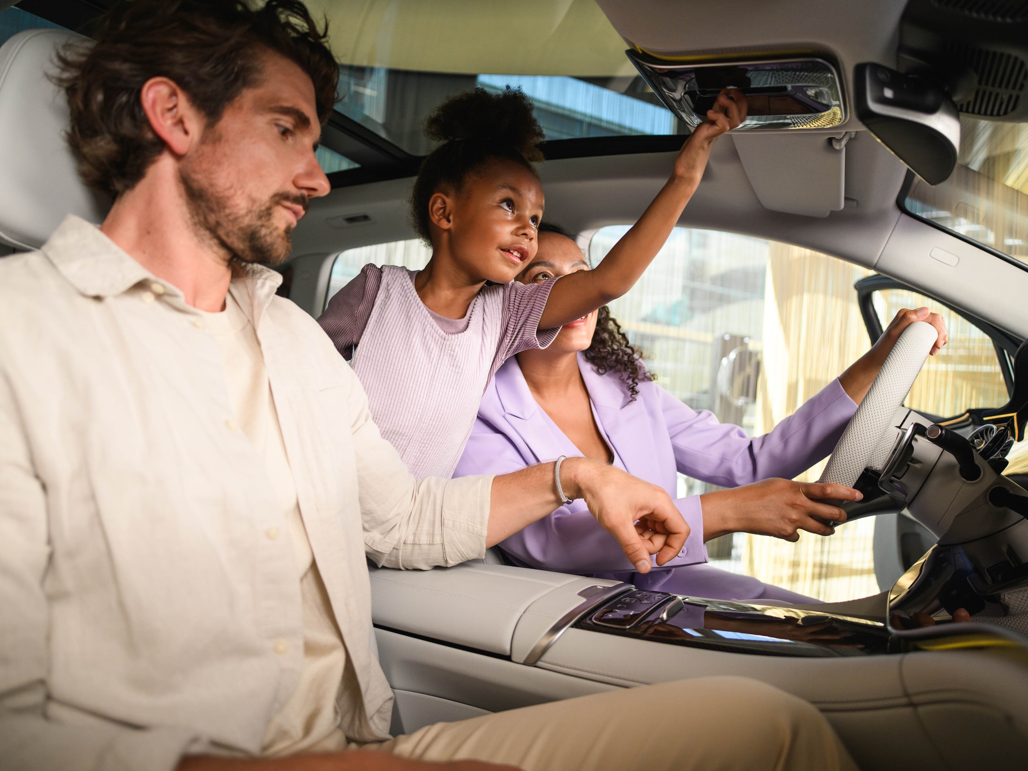 Drei Personen die in einem Mercedes-Benz sitzen. &nbsp;