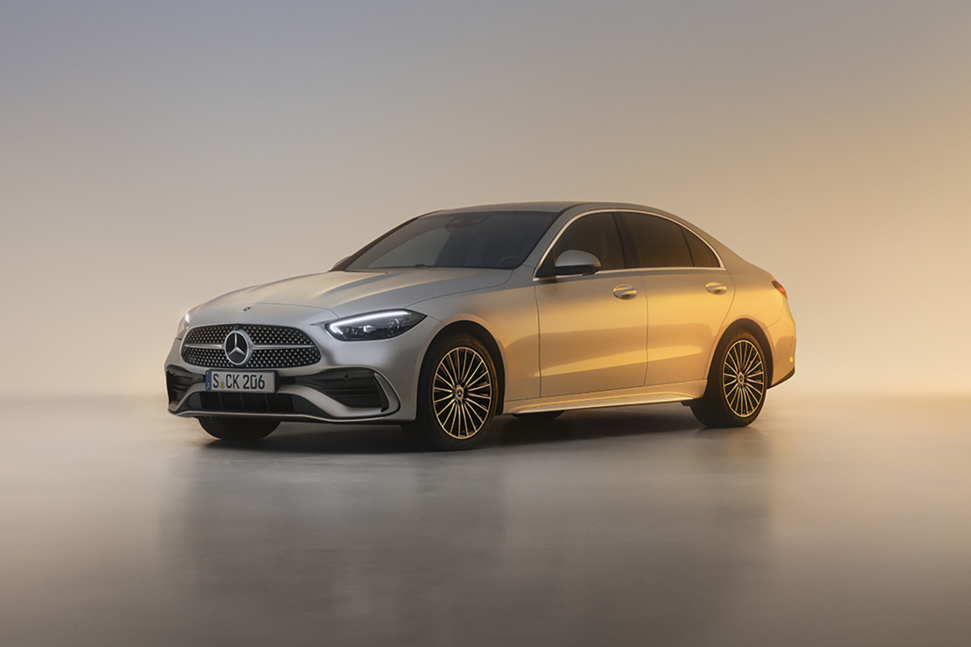 Fahrzeug-Angebote | Mercedes-Benz. Die C-Klasse Limousine, seitliche Frontansicht. Parkend vor einem hellen Hintergrund im Sonnenuntergang.