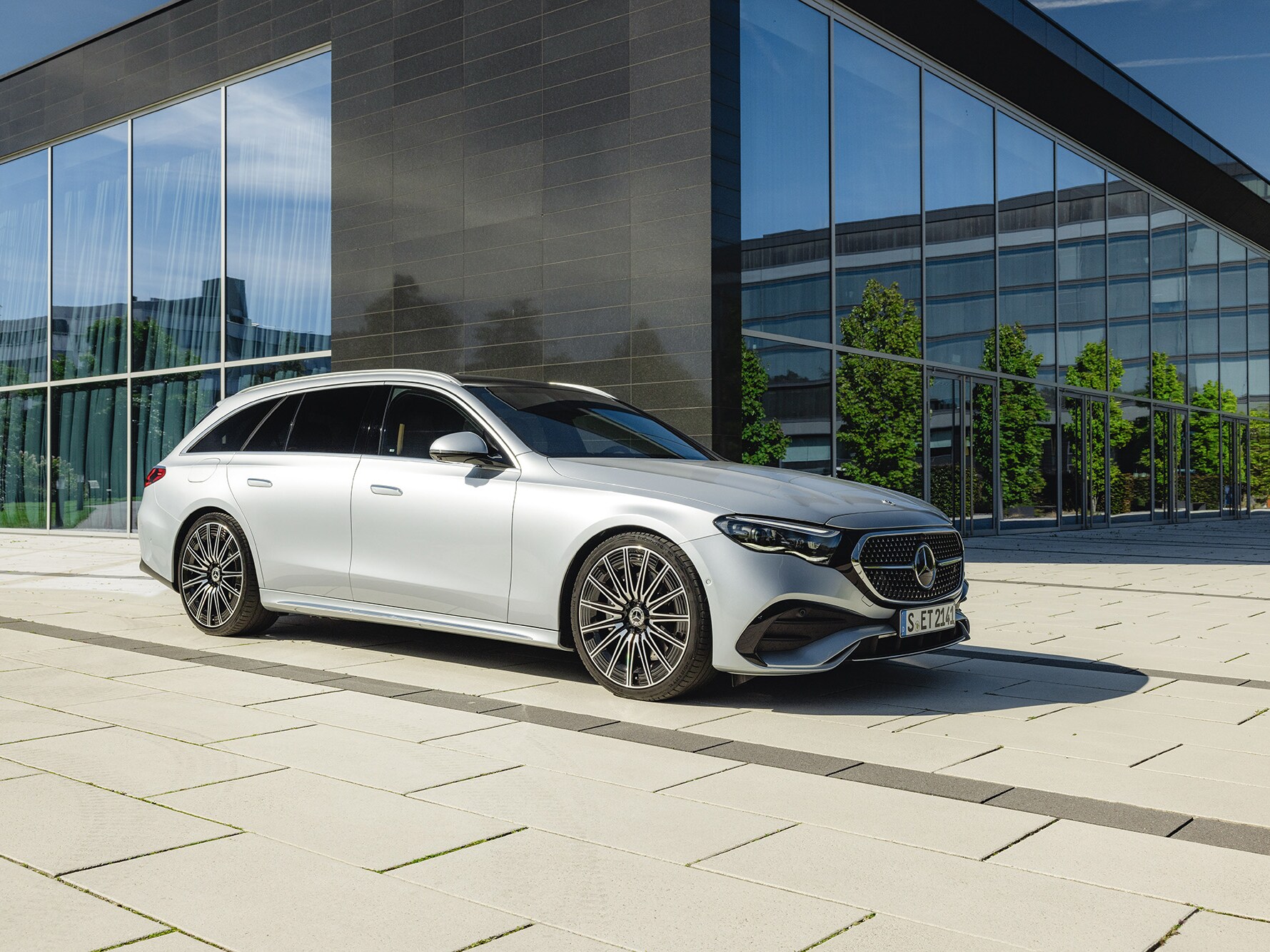 Eine silbergraue Mercedes-Benz T-Klasse parkend vor einem Bürogebäude.