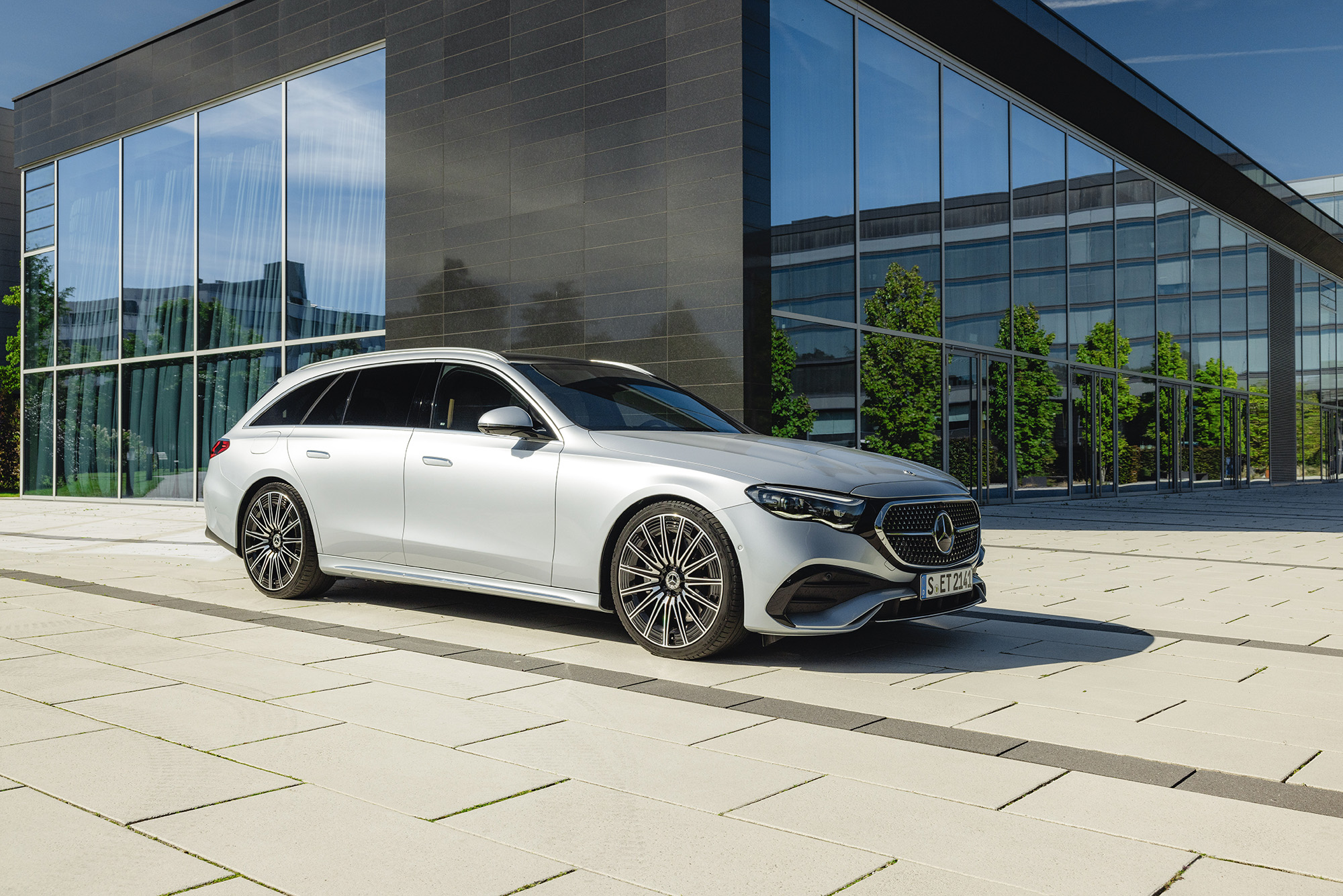 Fahrzeug-Angebote | Mercedes-Benz. Eine silbergraue Mercedes-Benz T-Klasse parkend vor einem Bürogebäude.