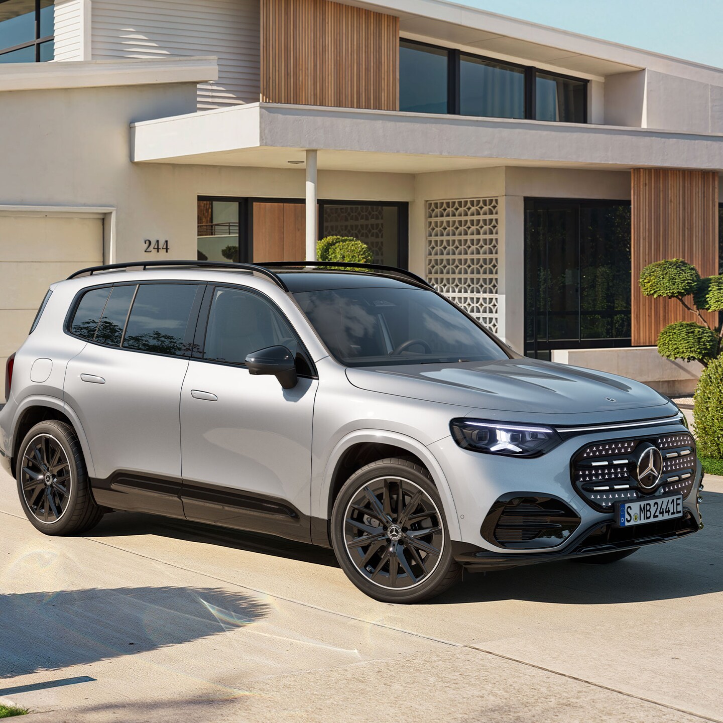 Ein silberner GLB mit elektrischem Antrieb steht auf einer Auffahrt vor einem hellen Wohnhaus.