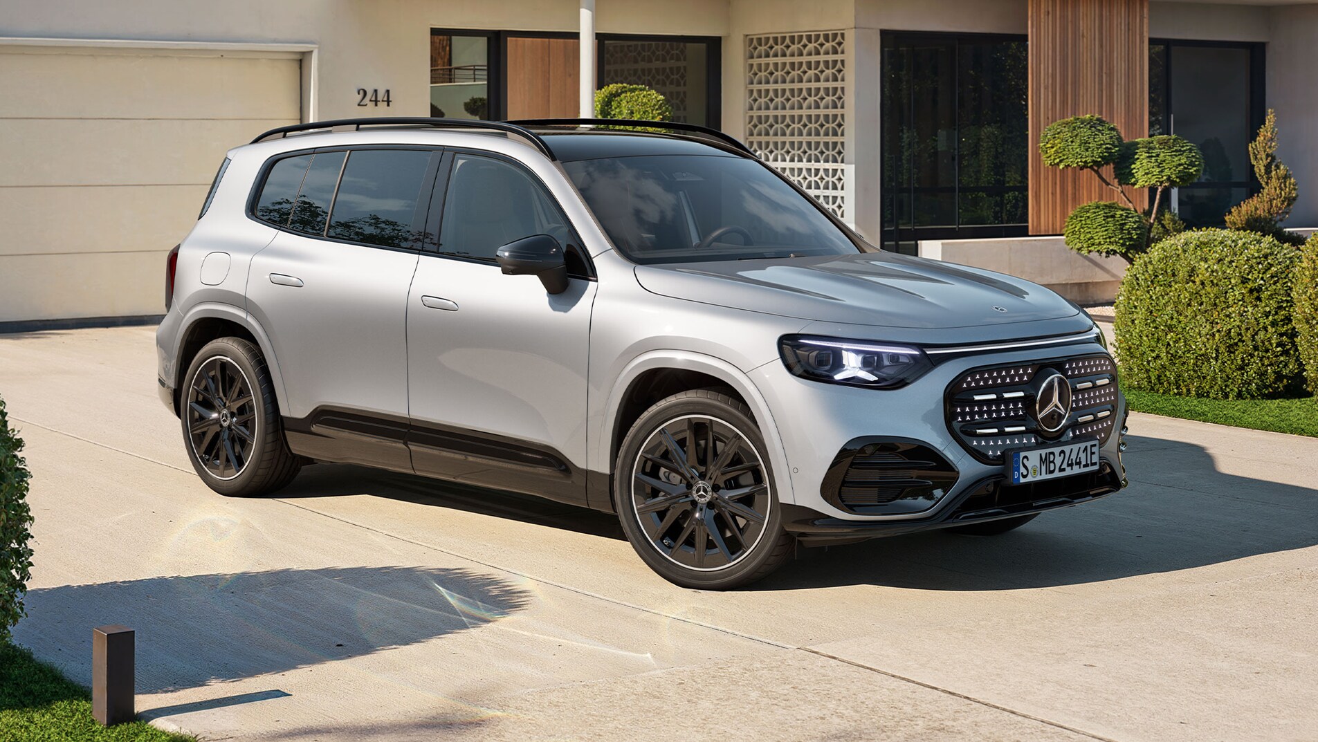 Ein silberner GLB mit elektrischem Antrieb steht auf einer Auffahrt vor einem hellen Wohnhaus.