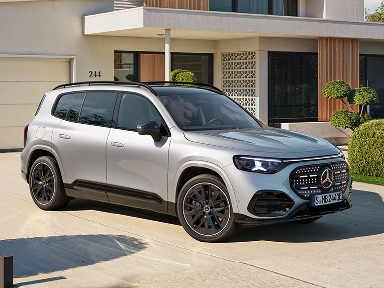 Mercedes-Benz Store | Mercedes-Benz. Ein silberner GLB mit elektrischem Antrieb steht auf einer Auffahrt im Grünen.