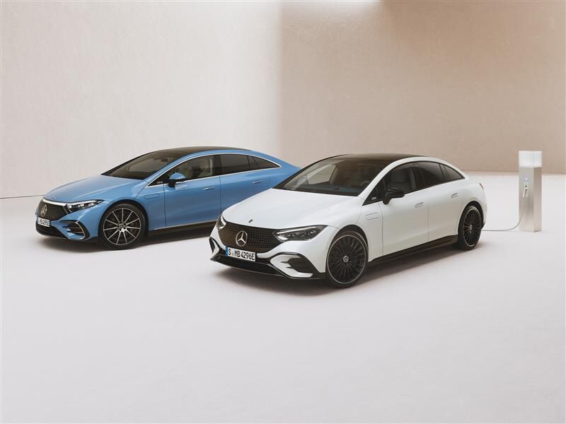 Mercedes-Benz EQE und EQS parkend in einem Showroom vor hellem Hintergrund.