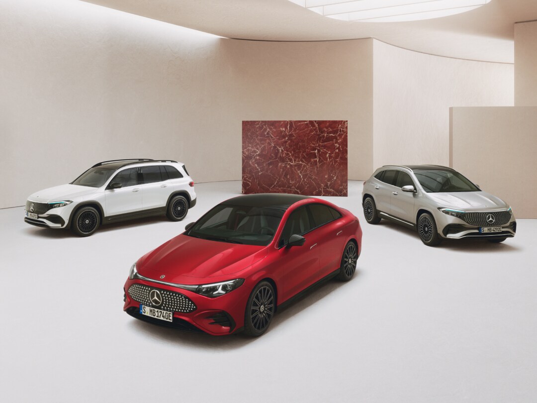 Drei Mercedes-Benz Modelle in seitlicher Frontansicht in Weiß, Rot und Silber in einem hellen Raum.