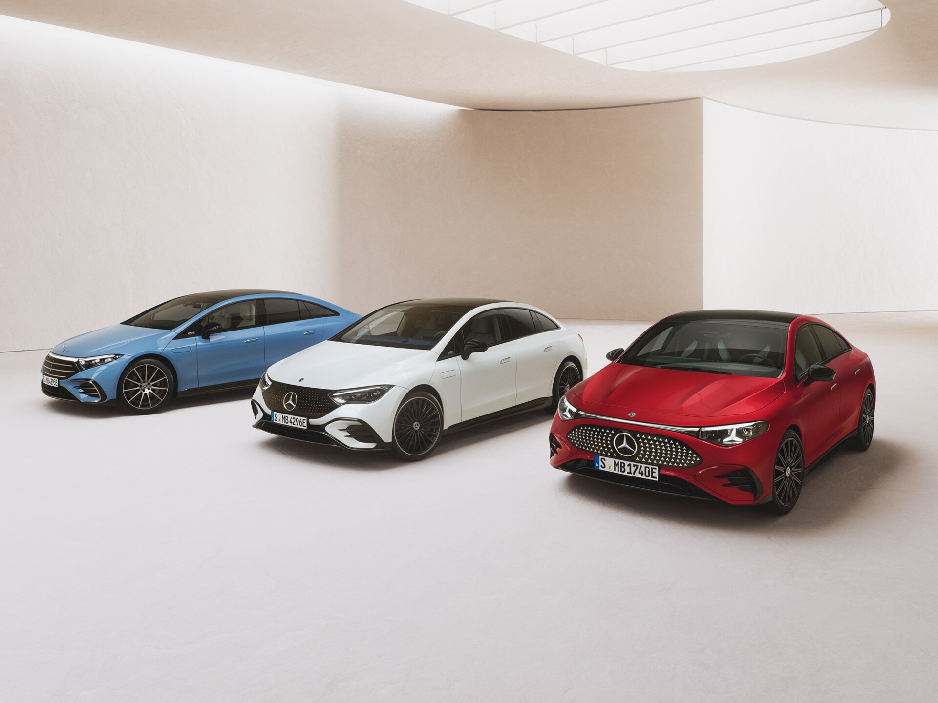 Mercedes-Benz CLA, EQE und EQS parkend in einem Showroom vor hellem Hintergrund.