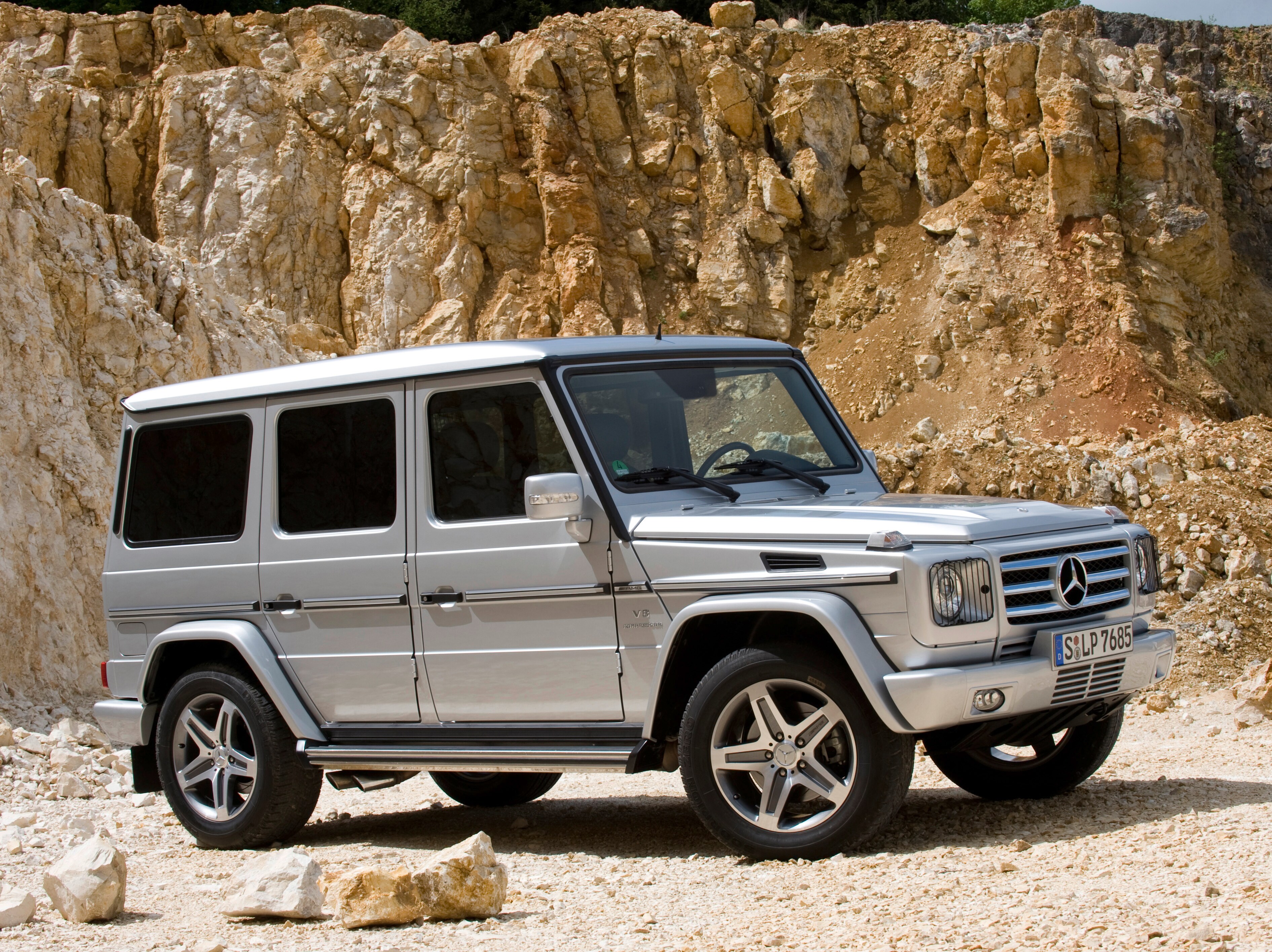 Eine silberne G-Klasse von Mercedes-Benz steht in der Sonne vor einer Felswand.